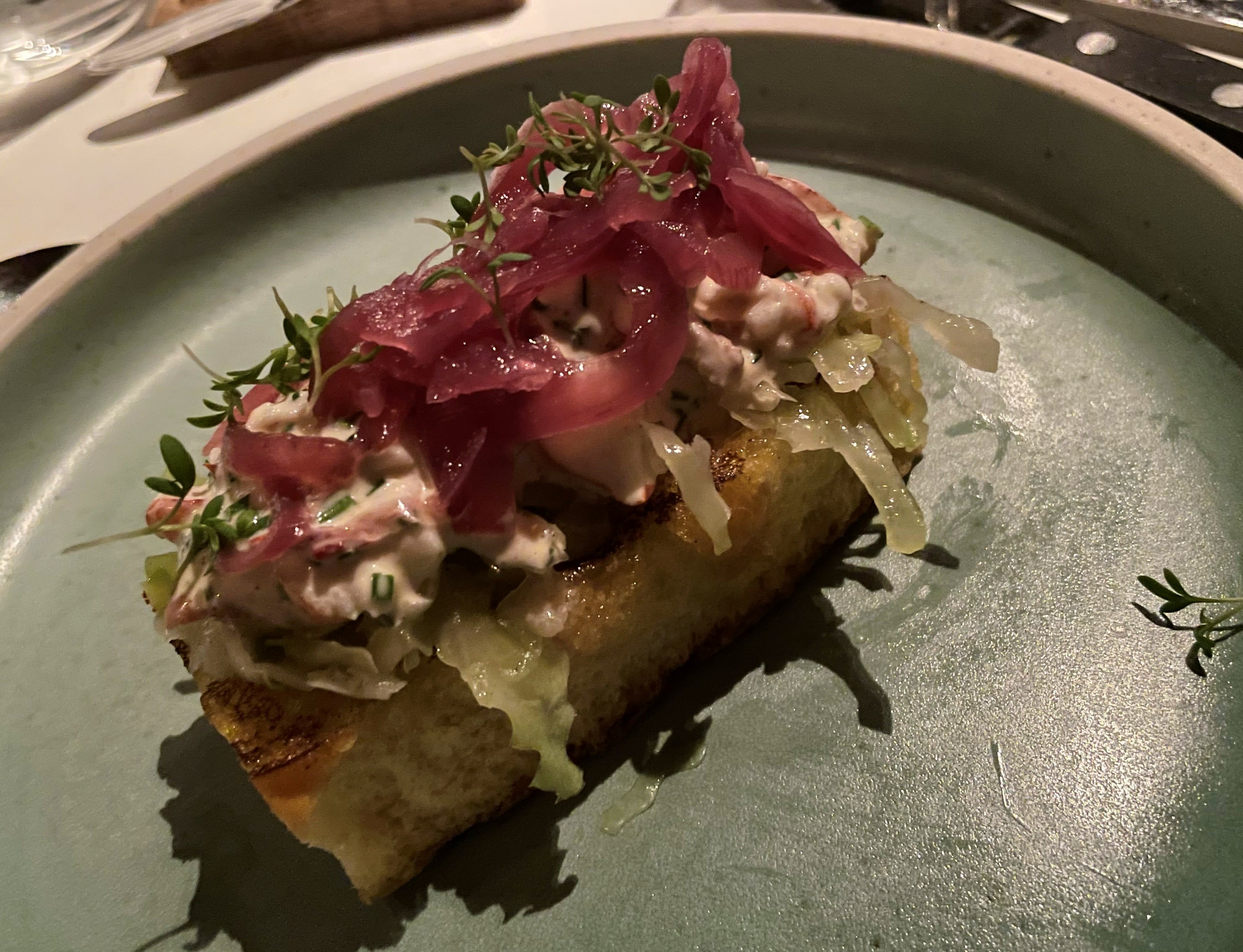 Hummerklør med brioche, kål og syltet løk.