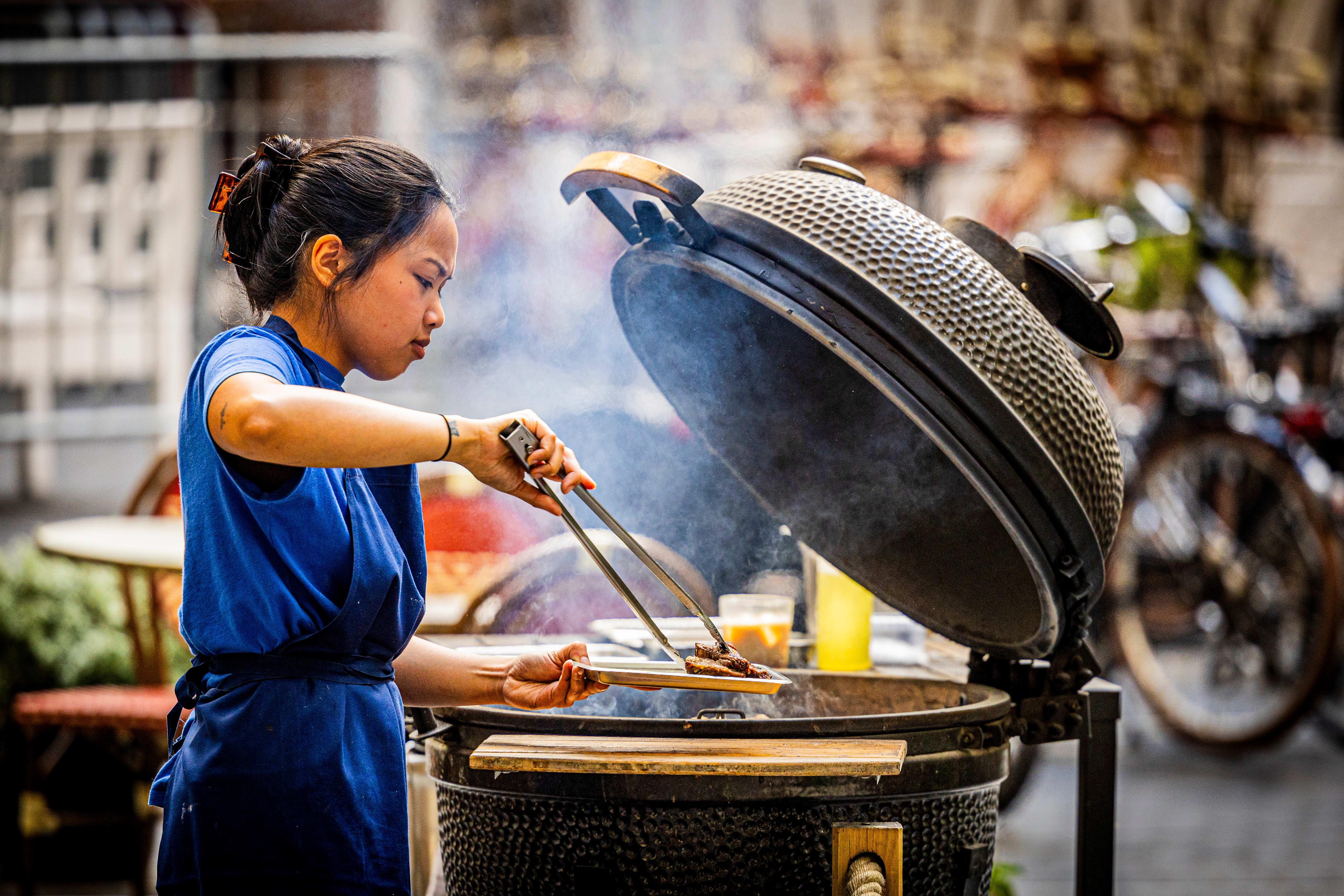 Halve menyen tilberedes på grillen som er plassert på uteserveringen.