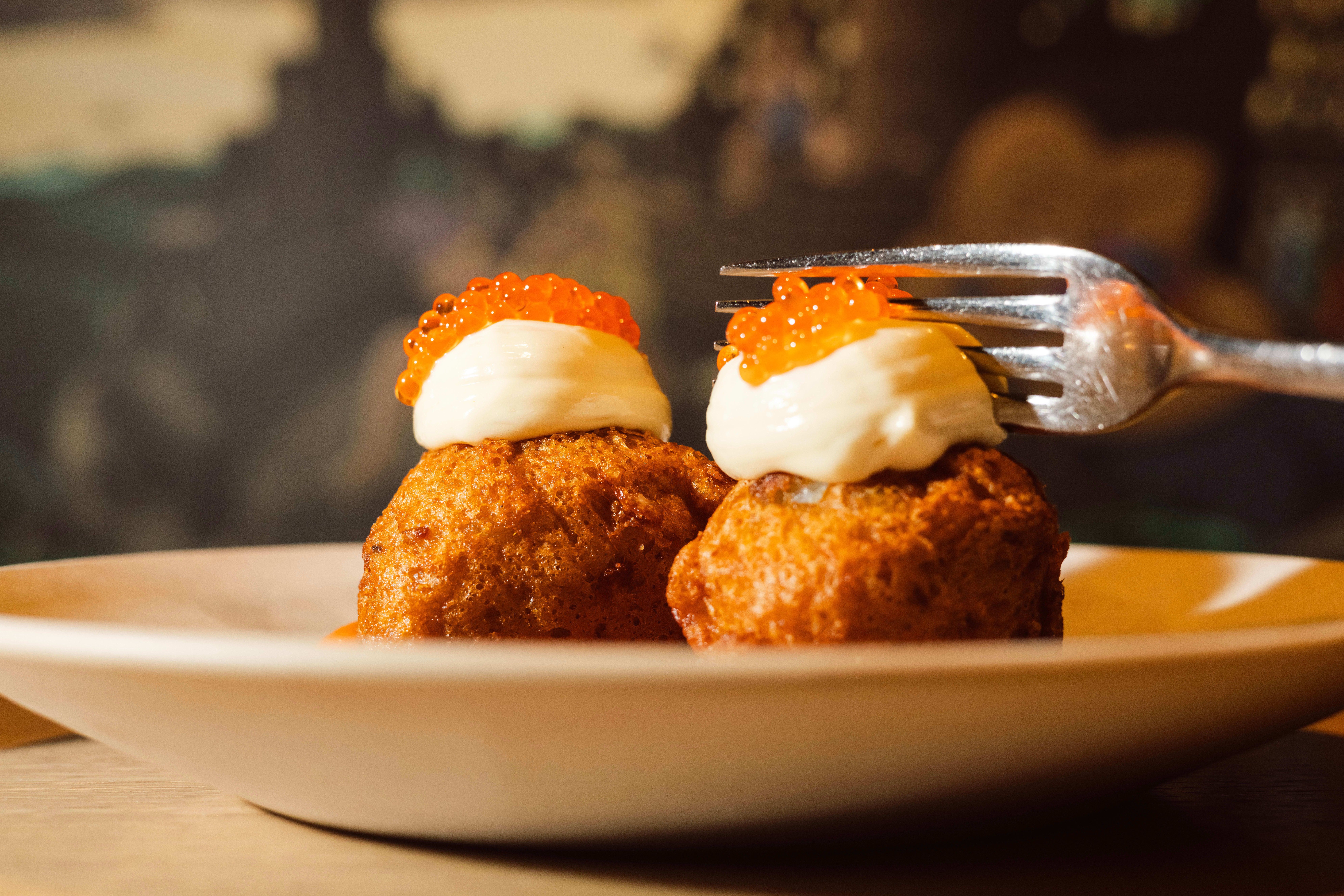 Bolinhos, friterte boller av mandelpotet, fylt med torsk og toppet med bravasaus, aioli og rogn.