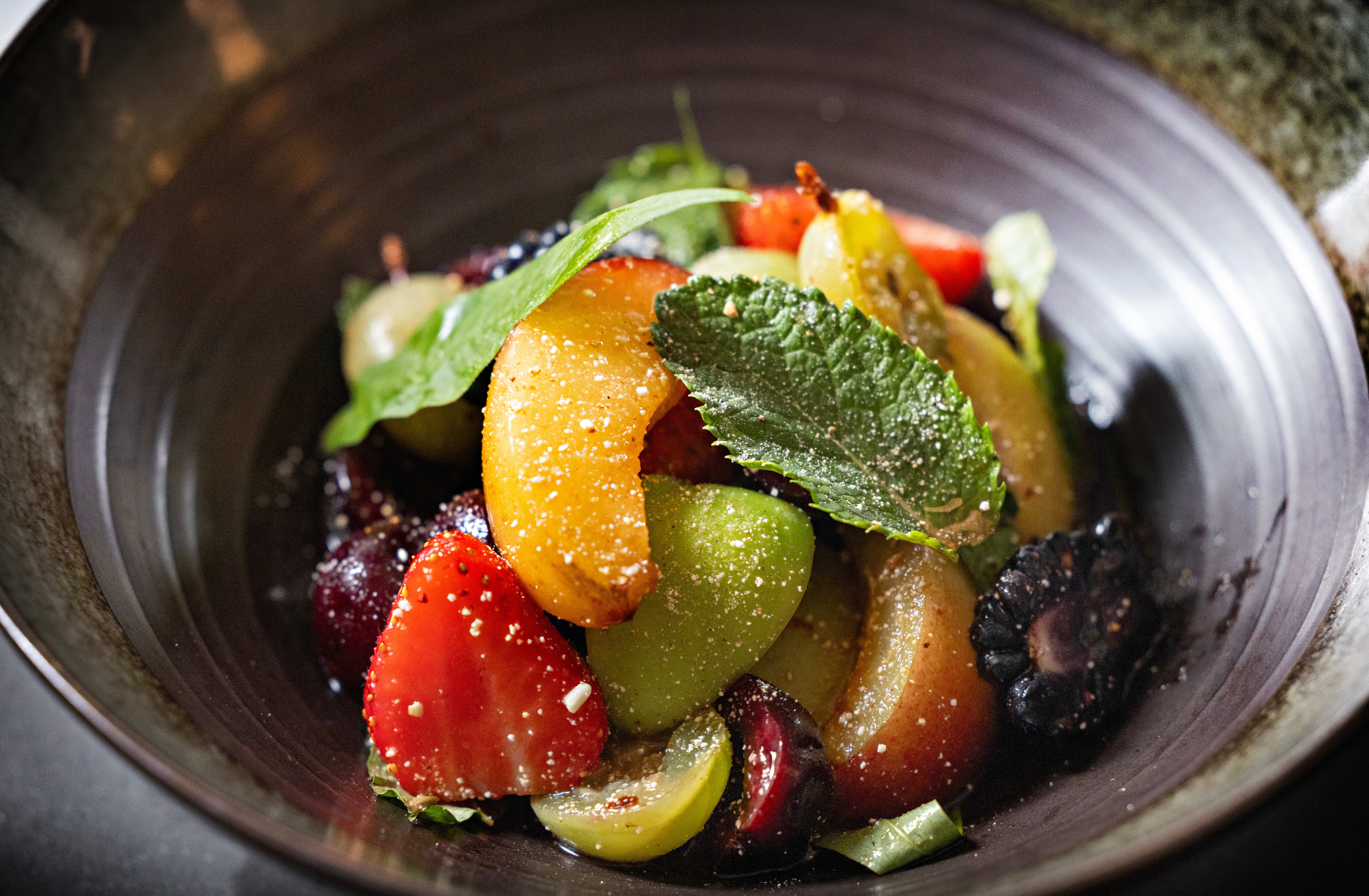 Bærsalaten har vært en favoritt hos gjestene, forteller innehaver Nud Dudhia, som har vært servitør de første to stappfulle ukene. Han forteller effektivt om inspirasjonen til rettene, mens kjøkkensjef Benjamin Roth holder i woken.