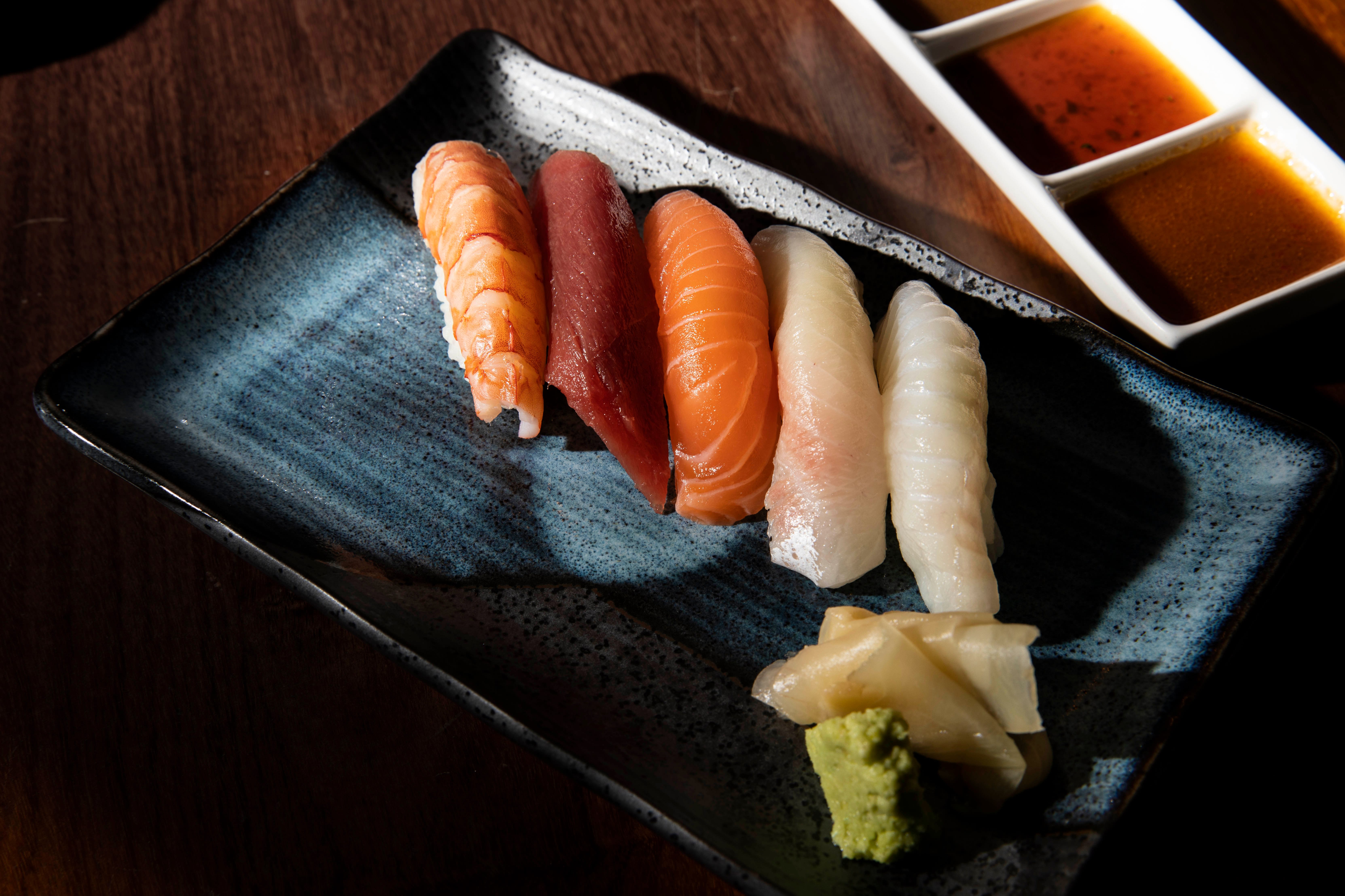 Alex Sushis nigiri ligger vakkert på blått stentøy. 