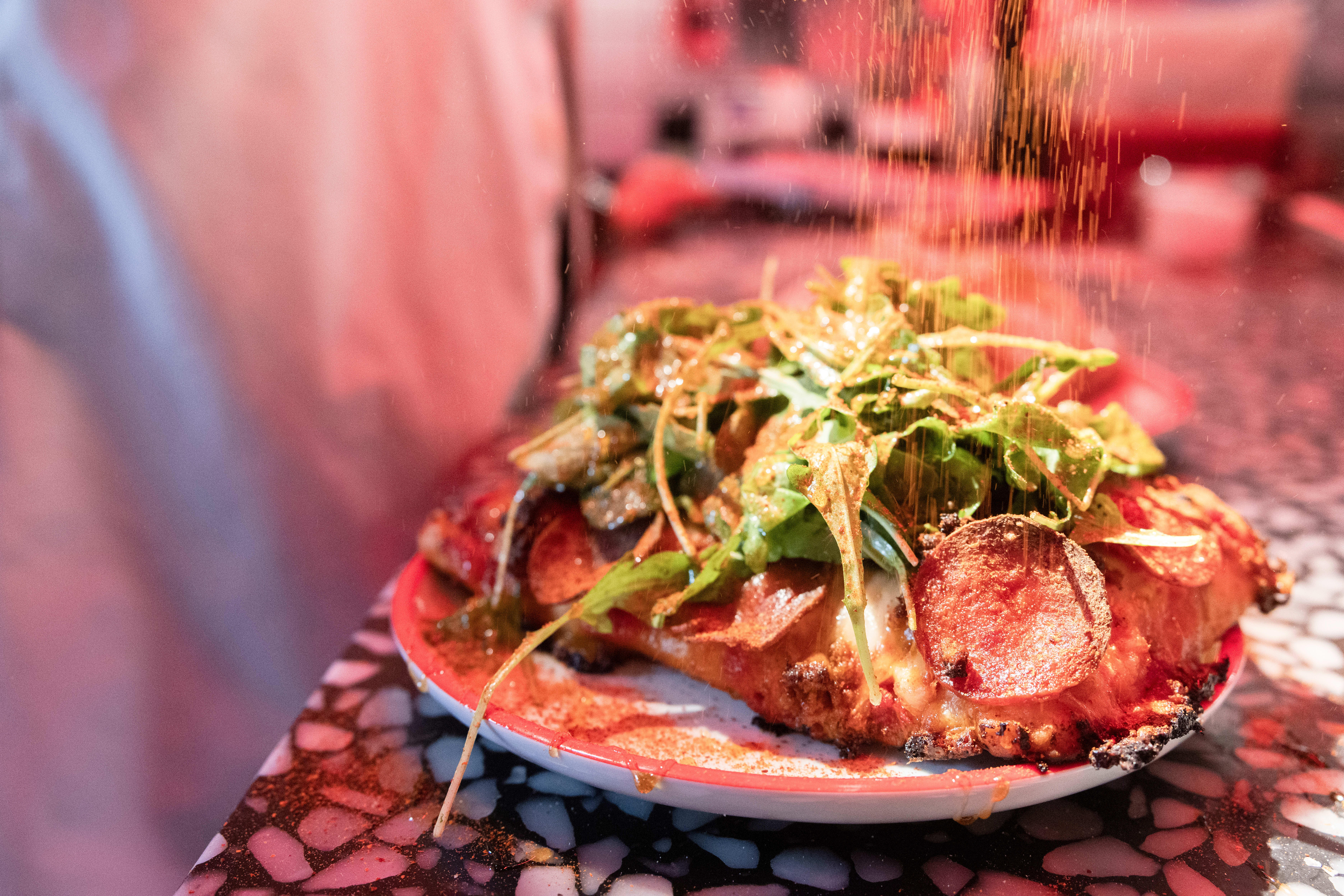 Pizza med nduja og pepperoni toppes med grønt og sterk honning.