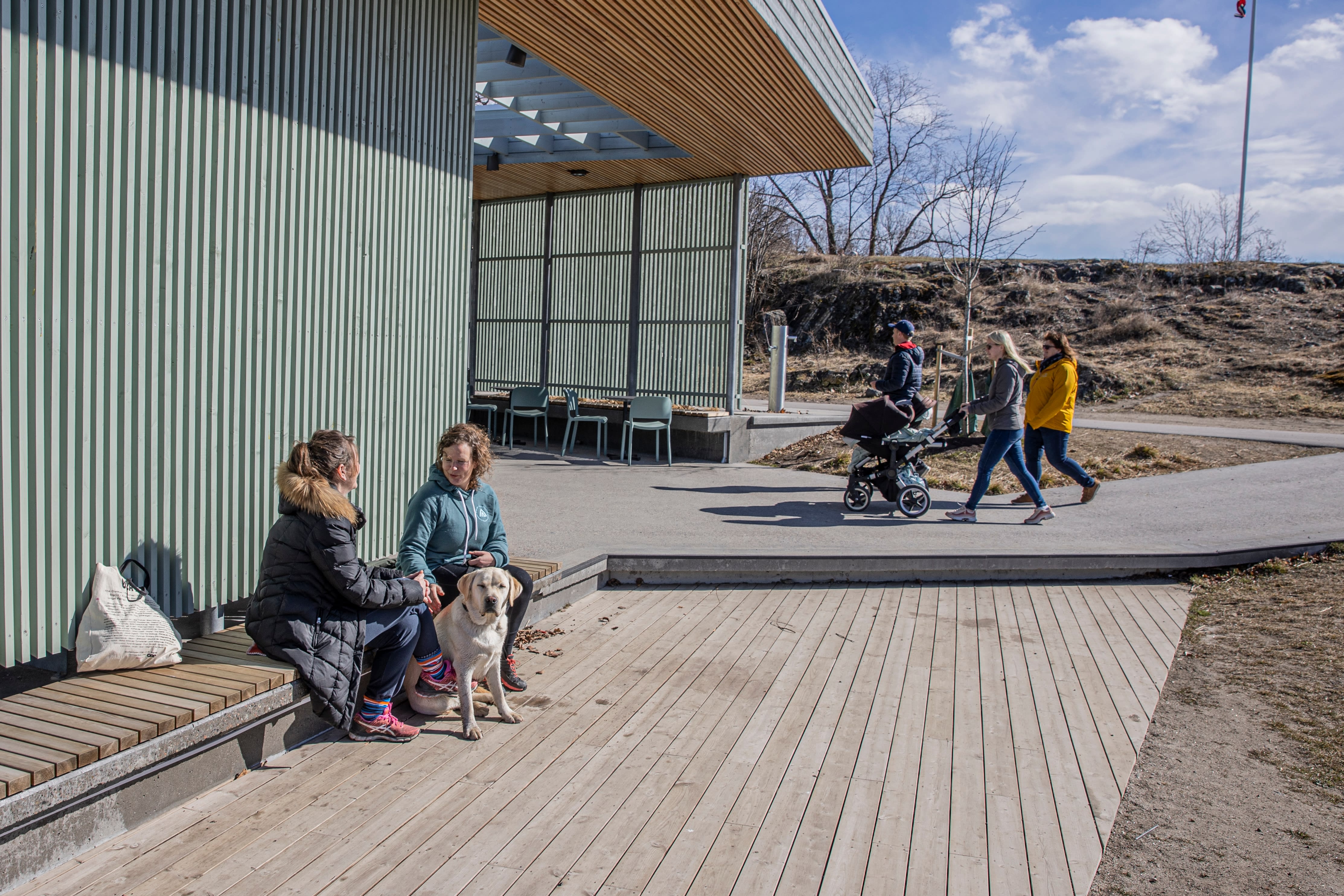 Gro Evensen og Anne Camerer samt Labradoren Enzo, som skal bli førerhund, nyter en kaffe i solen « Paahuk»