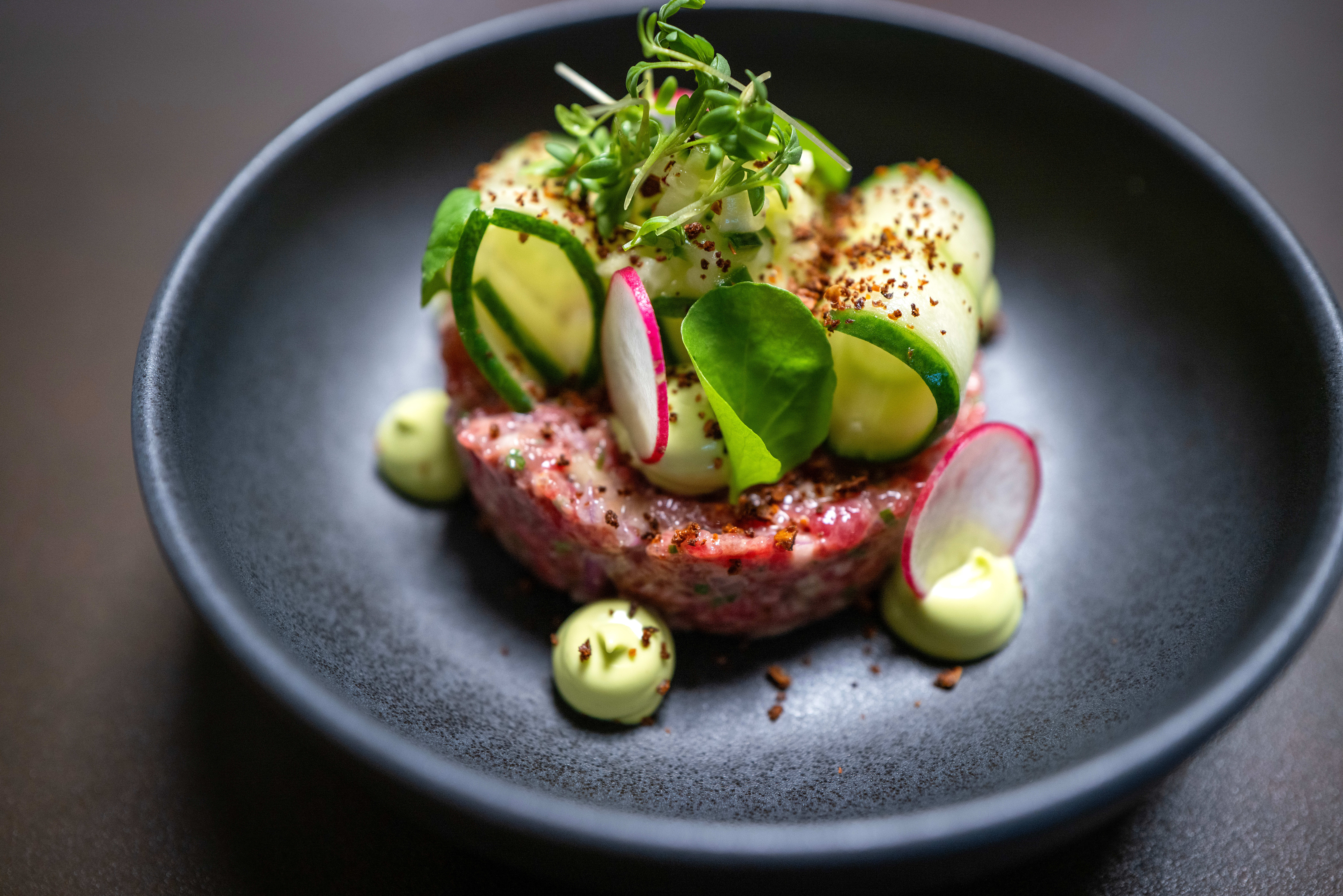 Torgterrassens tartar: Denne kunne vært hakket mer grovmalt, men er fint krydret. Den har med biter av sylteagurk, smakfull gressløkmajones og sprø surdeigschips til alt det myke i retten. 