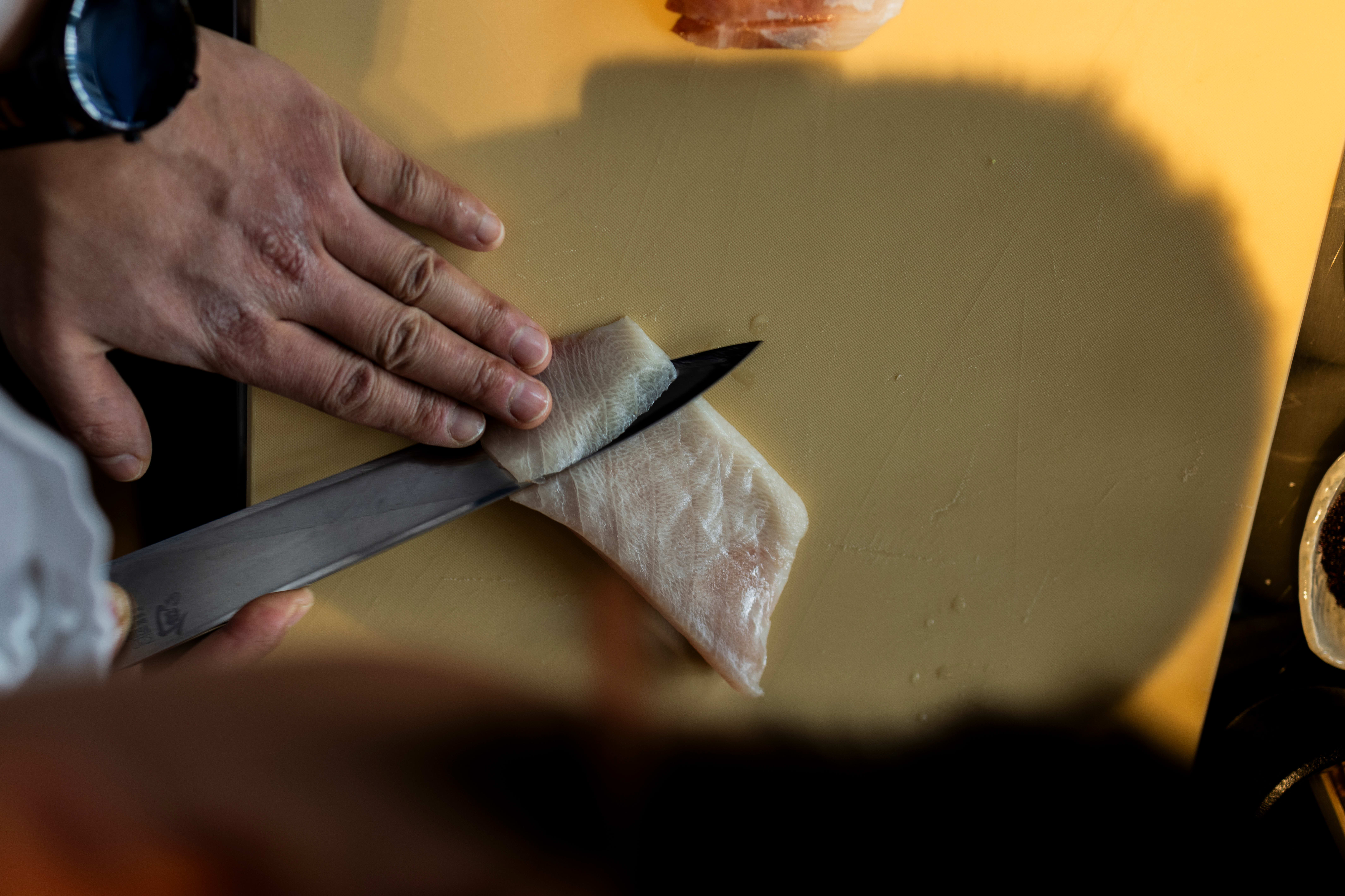 Hvis du sitter i baren, kan du følge med når kokken skjærer opp fisken. På sushirestauranter lager man ofte slike rektangulære stykker, som kan skjæres til pene skiver. Teknikken kalles hira-zukuri. 