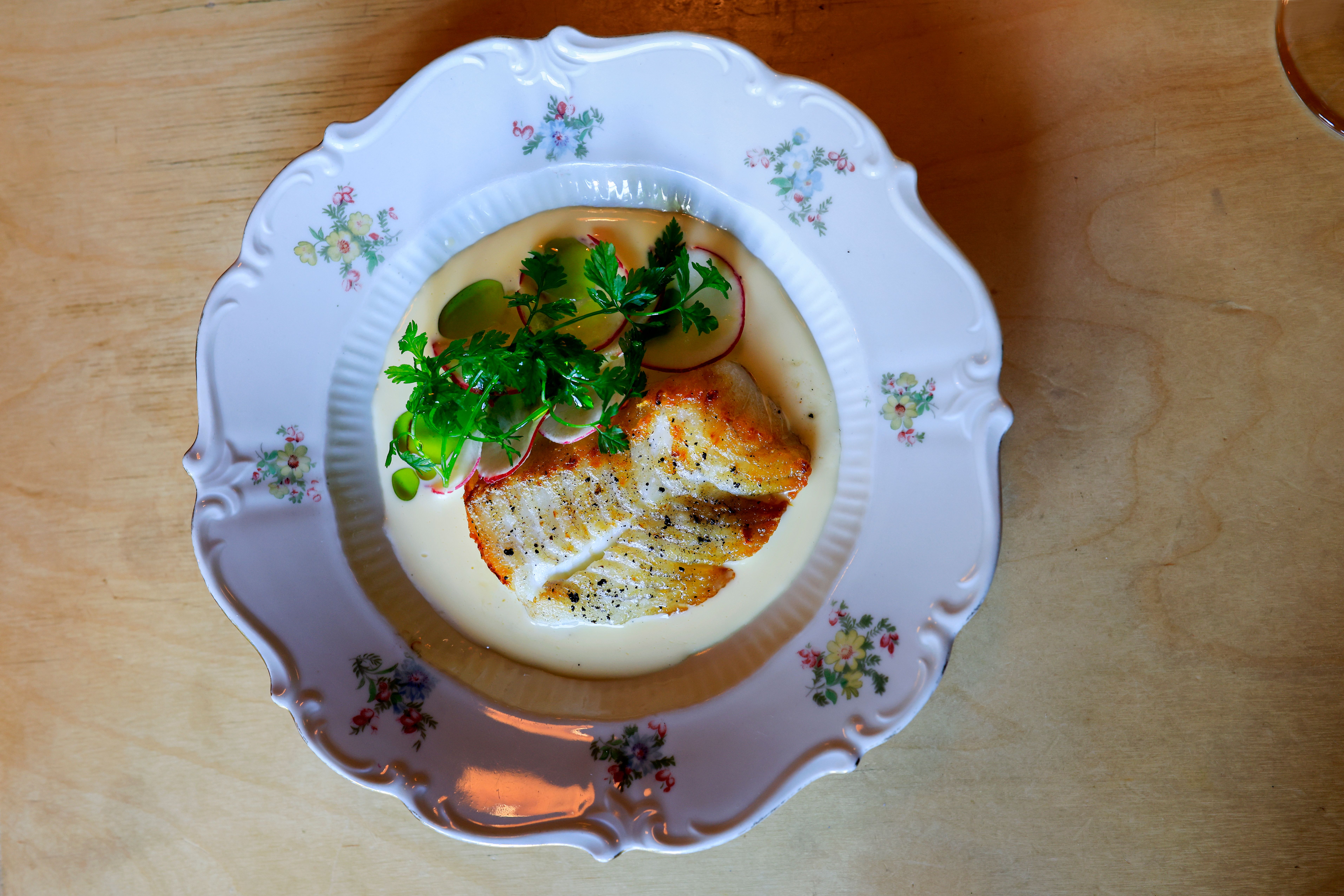 Bifangst med smørsaus, reddik og urtesalat.