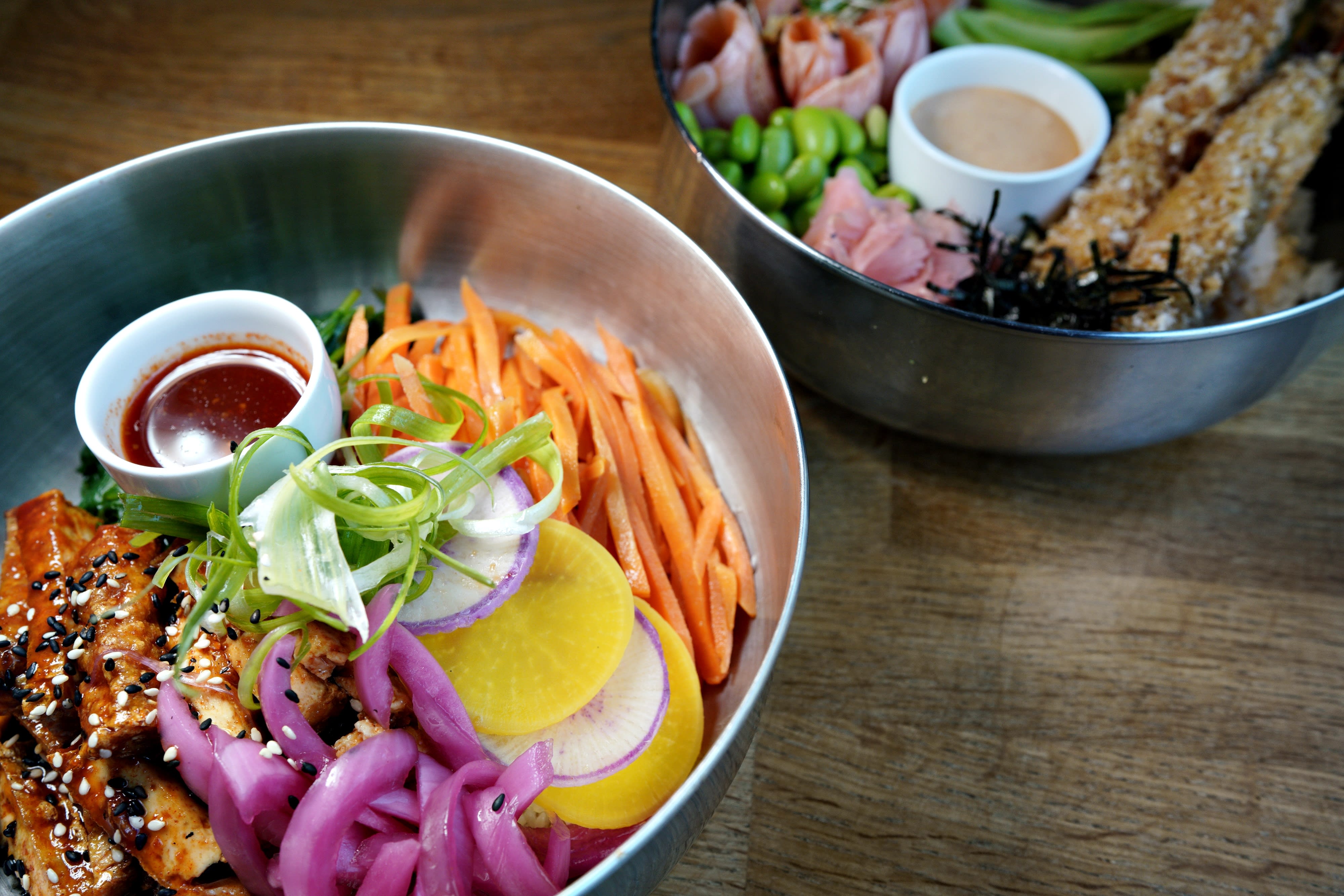 Boller med ris dekket med proteiner og grønnsaker. Koreansk inspirert Bulgogi-bowl til venstre. 