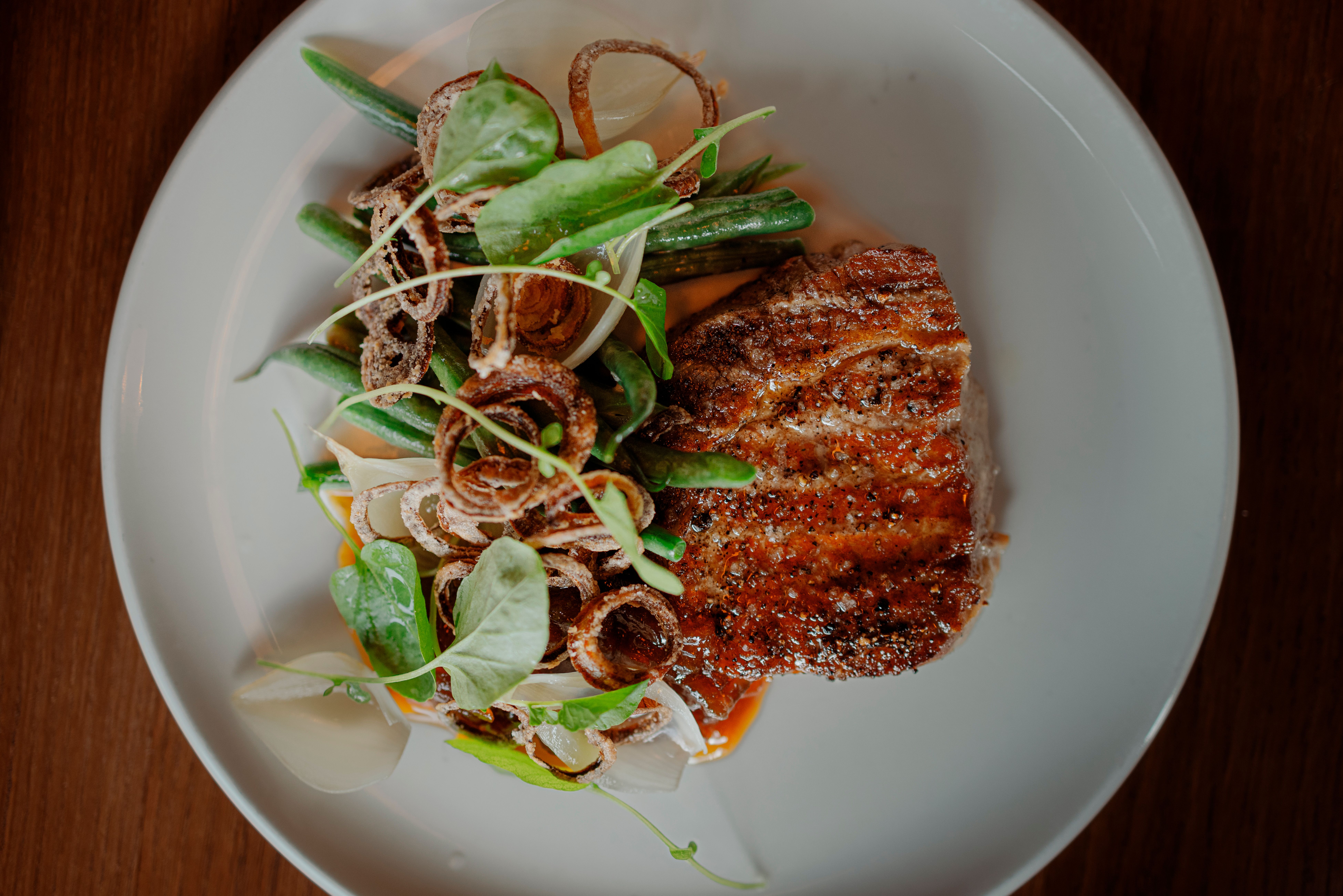 Meget god kalve-entrecôte med bønner og karamellisert løk.