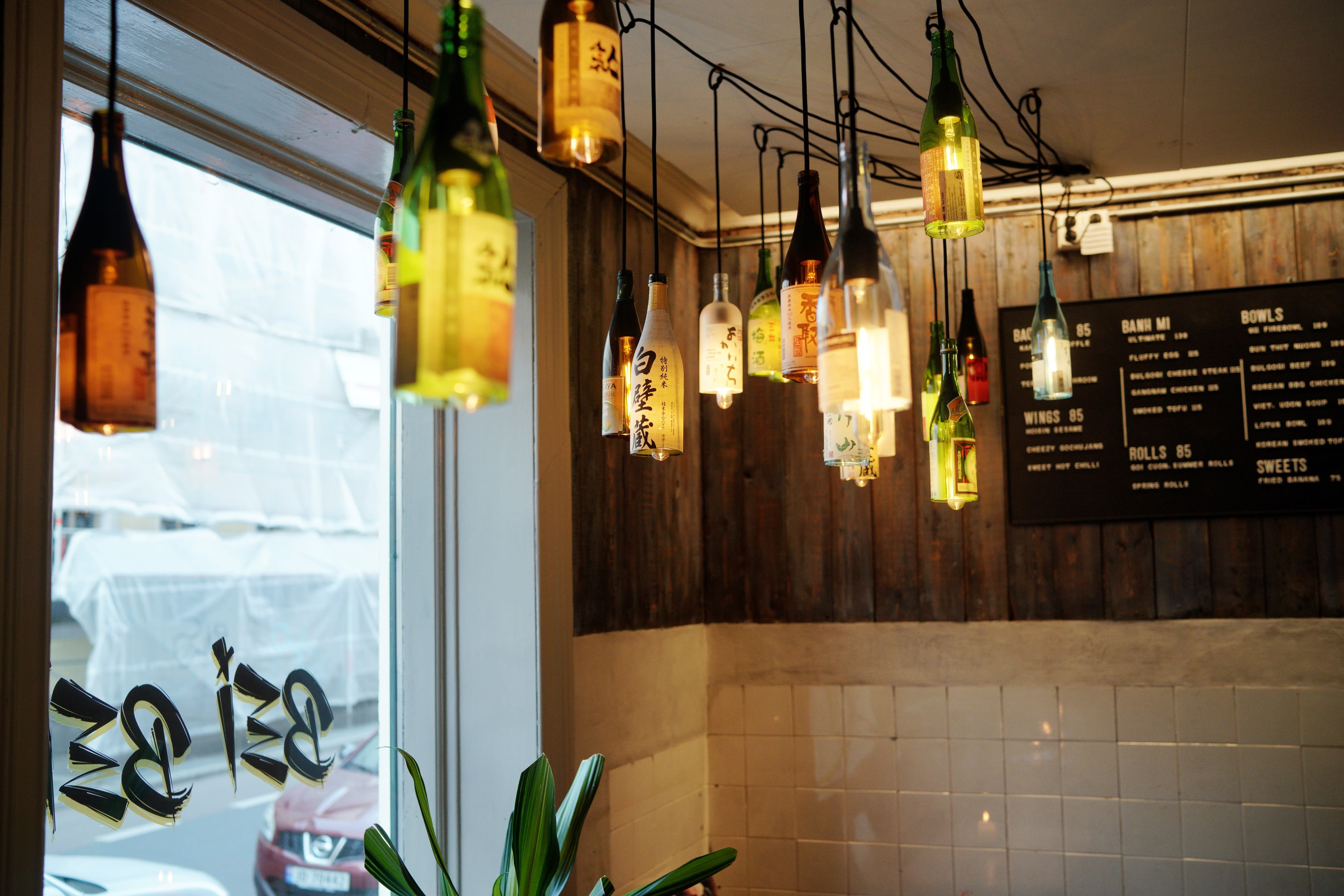 Morsom gjenbruk av vinflasker i vinduet.