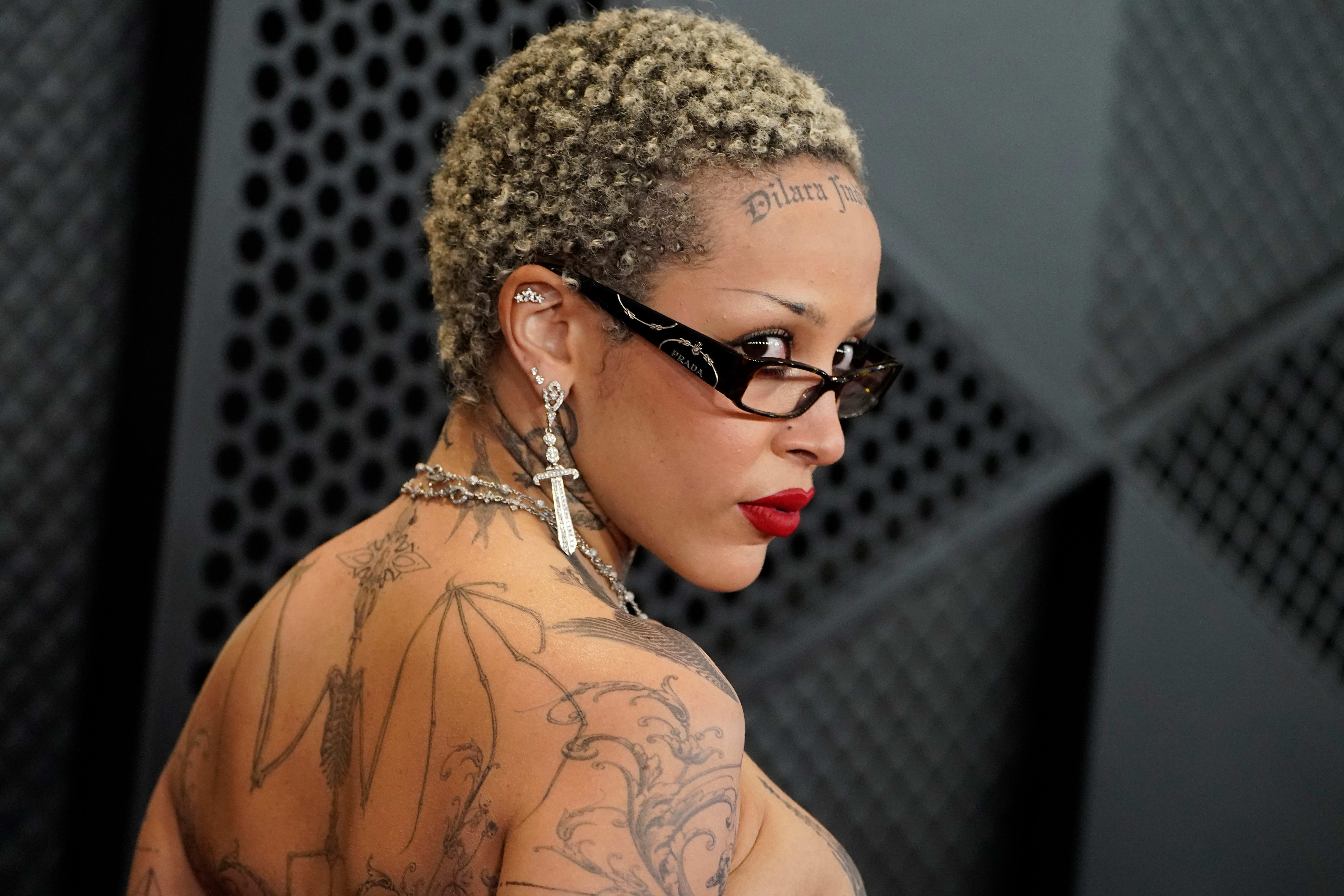 Doja Cat kikker over brillene sine, som ser ut som de er rappet rett fra settet til The Devil Wears Prada.  