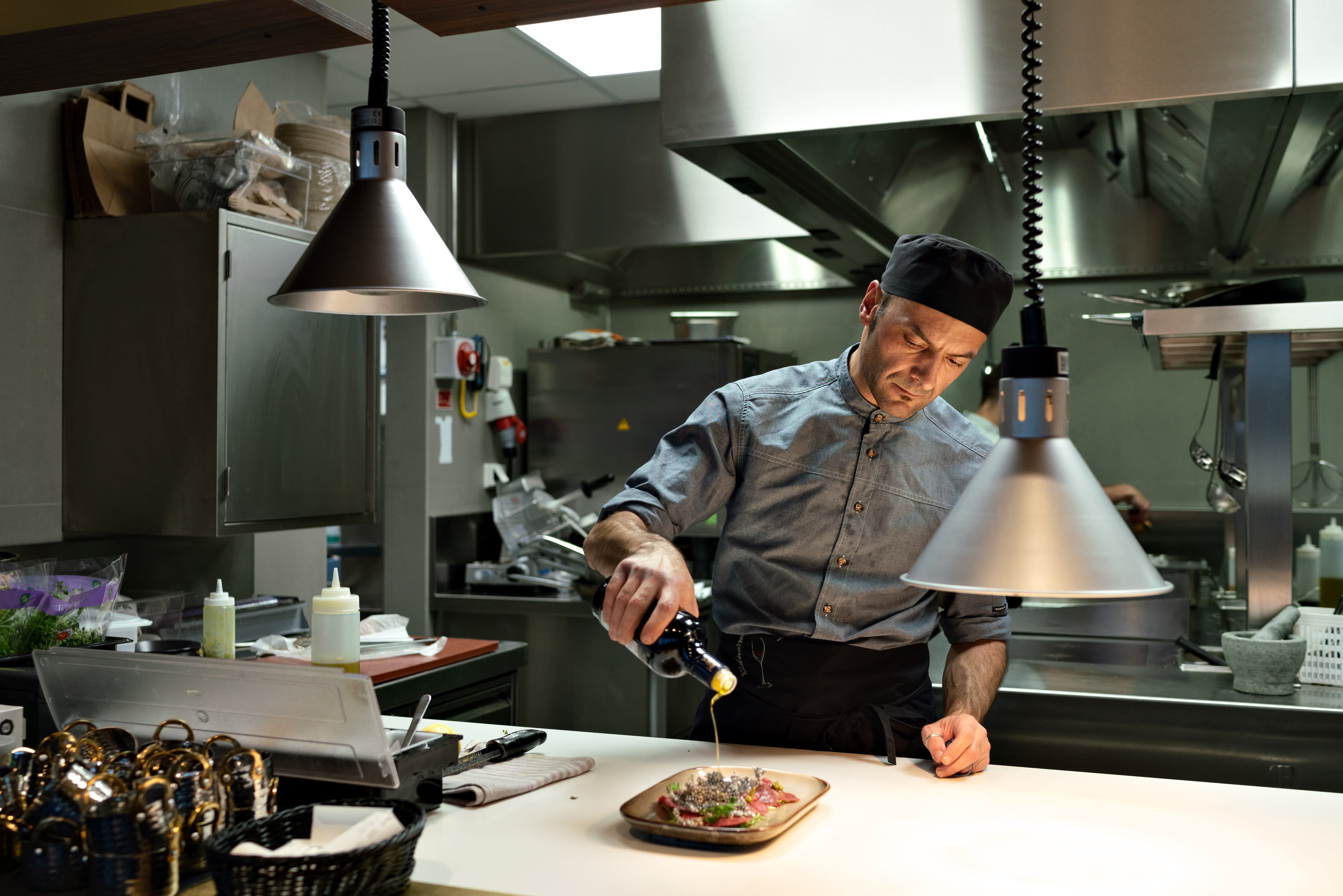 Soussjef Marco Marsili heller olivenolje på carpaccio di manzo.