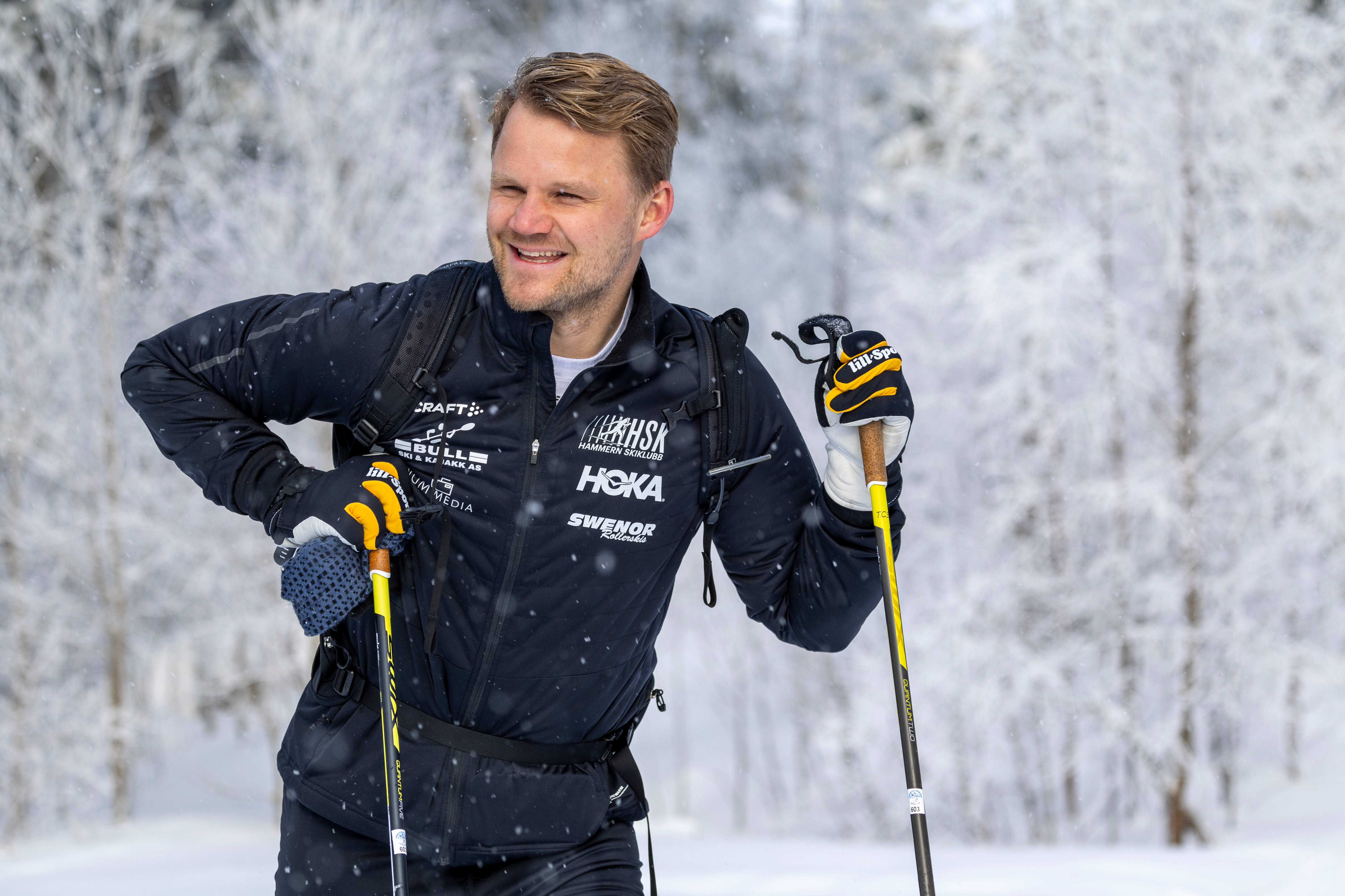 Jonas Bergh-Johnsen speider etter sommer og Spritz blant snødekte trær.