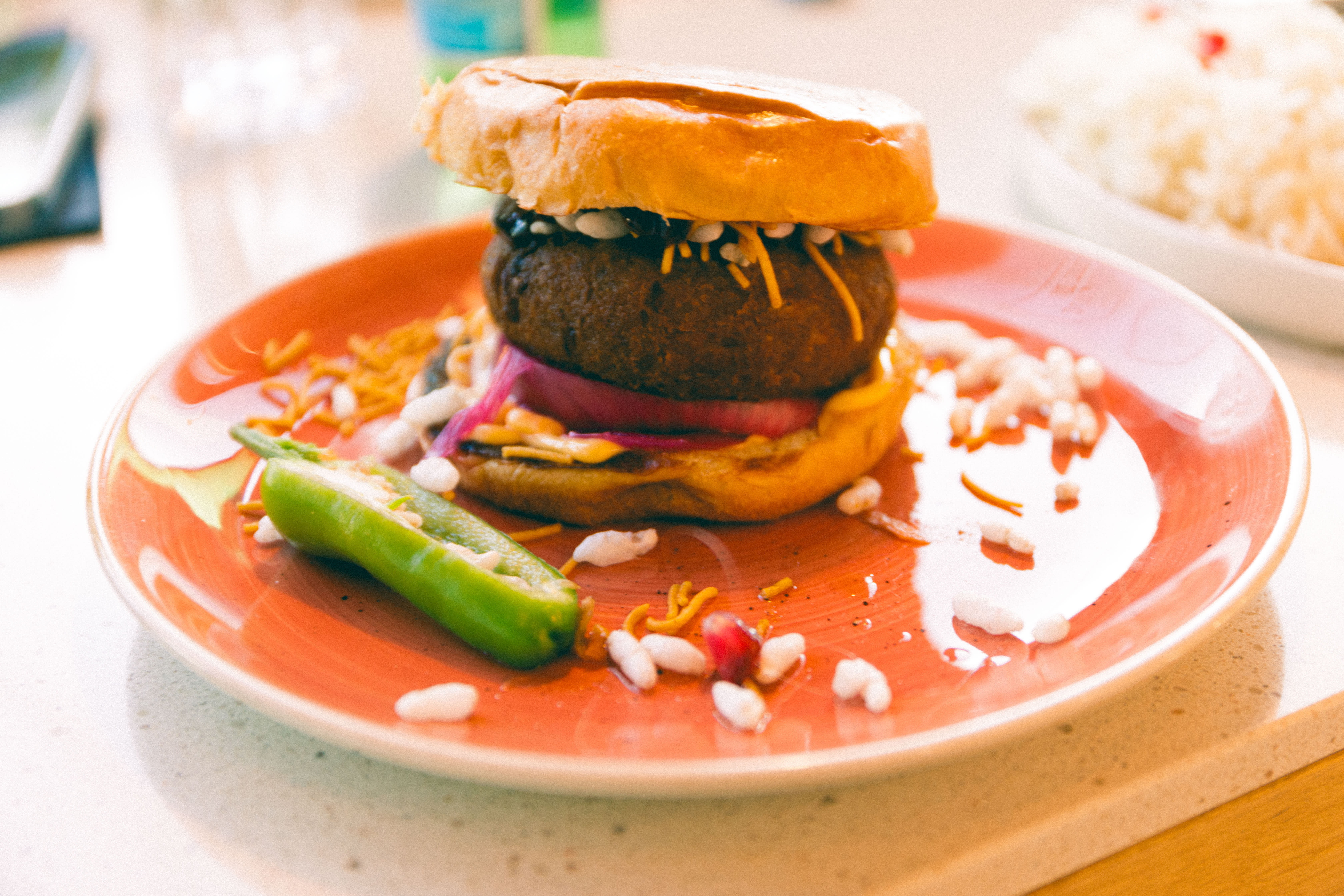 Aloo tikki burger med puck av potet.