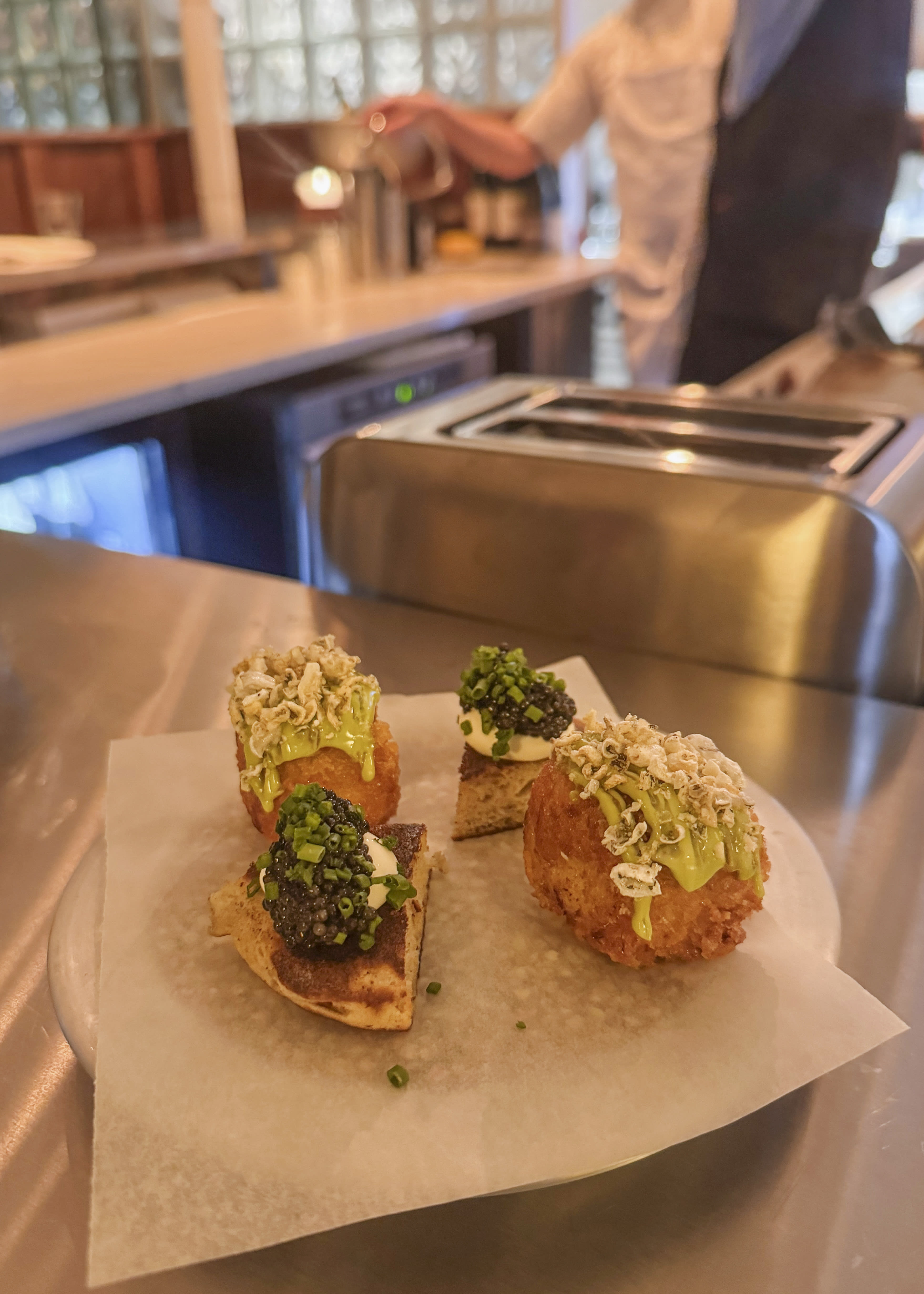Kaviar på blinis og kroketter med sprøstekt torskeskinn på toppen. 