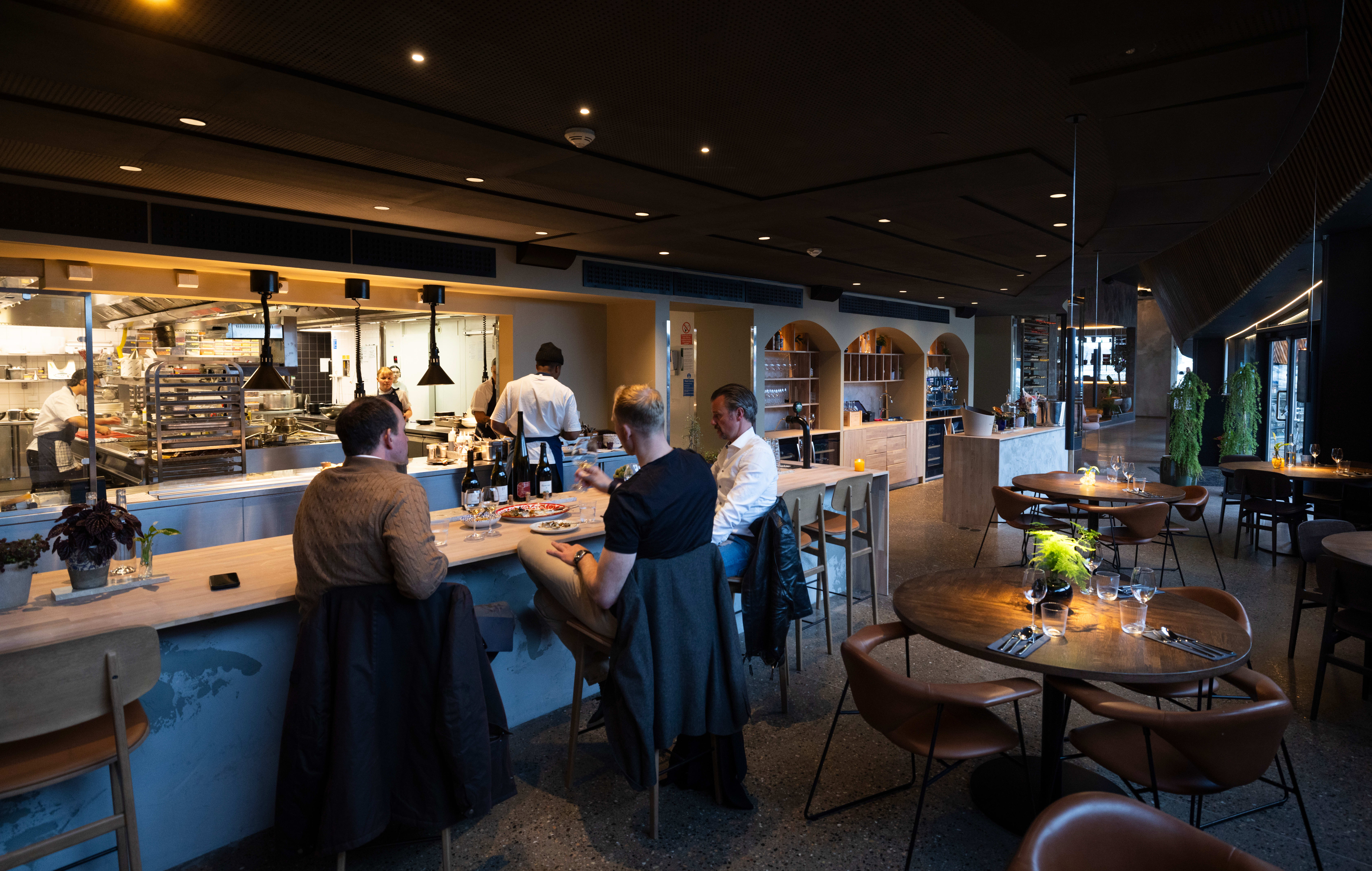 Fine plasser i baren med utsikt til kjøkkenet.