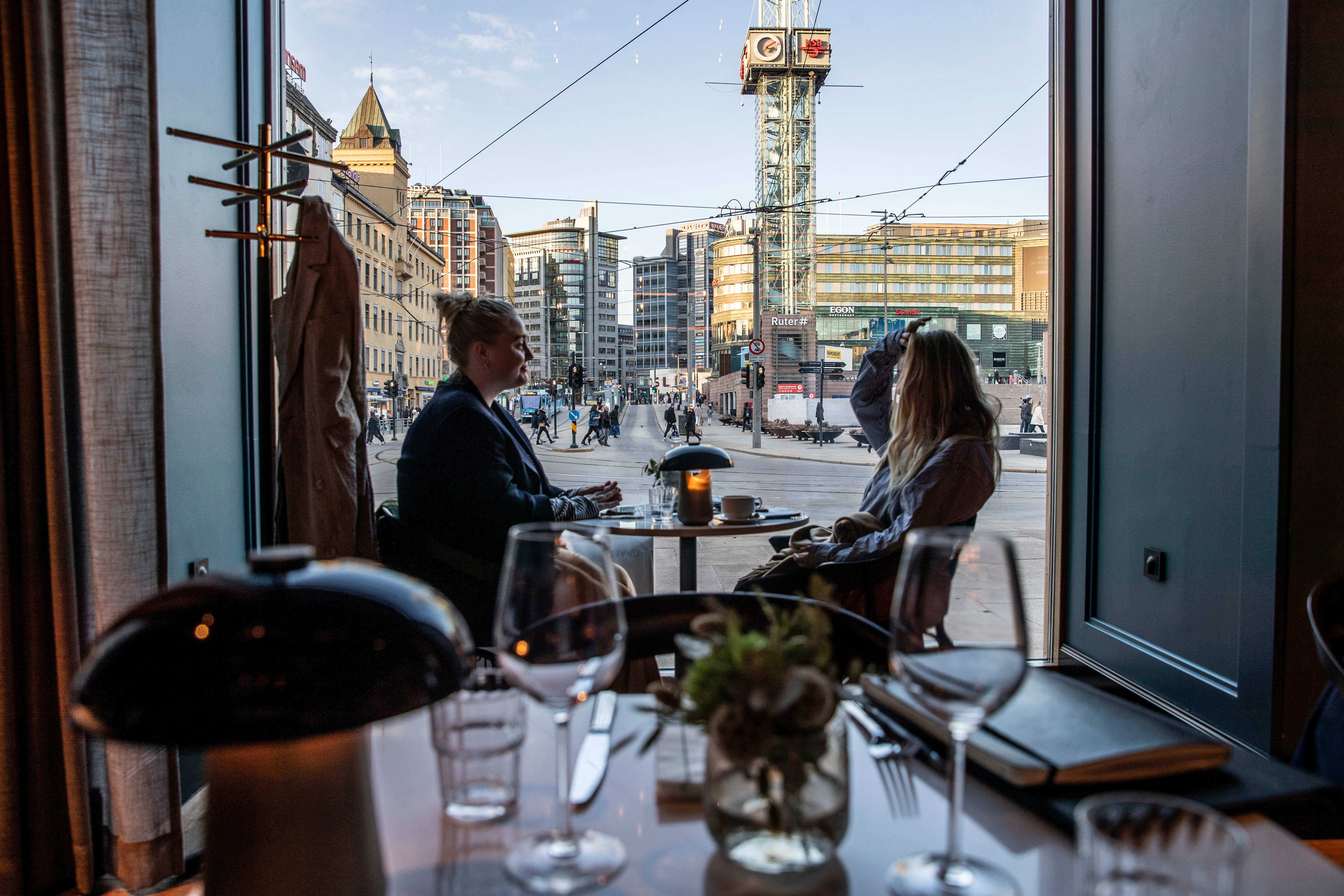 Store vinduer mot blå trikker og røde busser. 