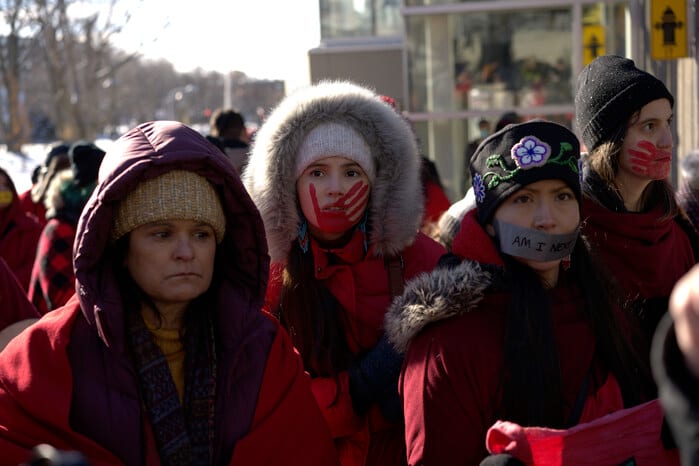 Arisawe Two-Rivers (Georgina Lightning) og Kara Two-Rivers (Isabel Deroy-Olson) protesterer mot politiets handlingslammelse.