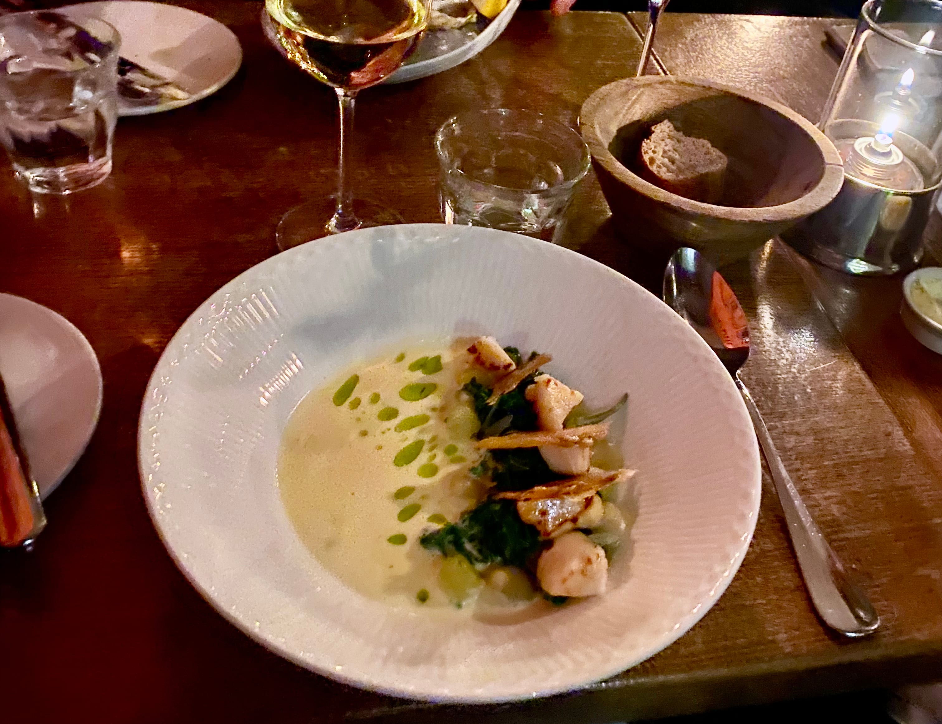 Grillede kamskjell med sprøstekt kyllingskinn, kremet suppe og estragonolje. 