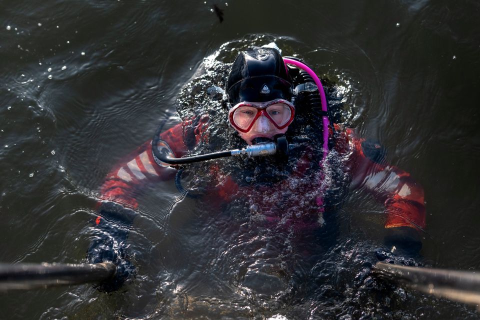 En ung jente med dykkerutstyr går ned i vannet.