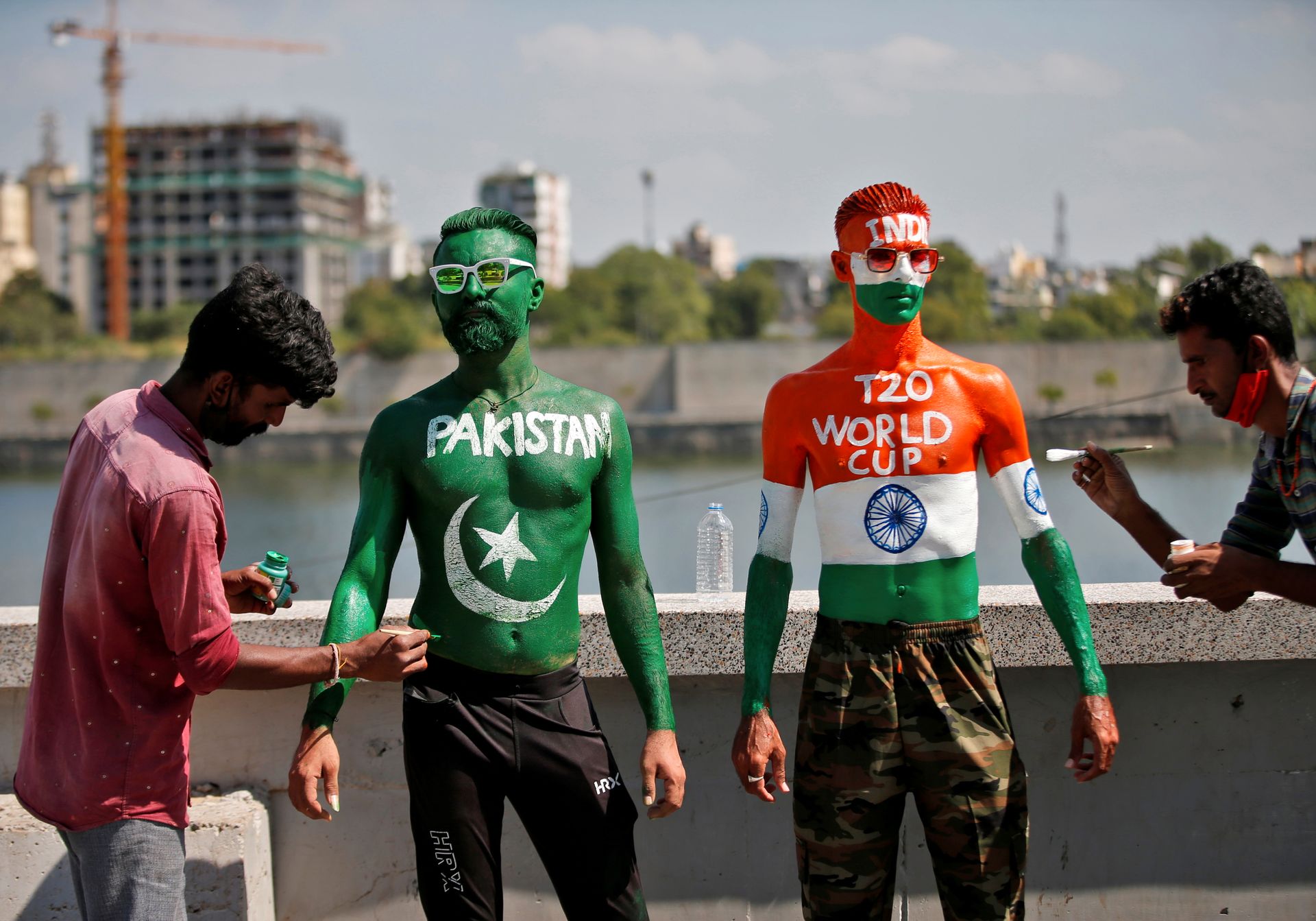 To menn med solbriller har malt det indiske og det pakistanske flagget rett på kroppen. 