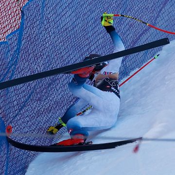 En person med ski på beina kræsjer inn i et sikkerhetsnett.