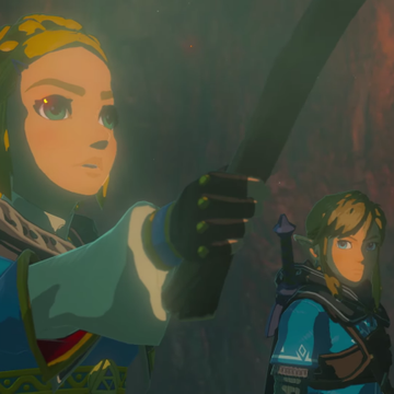 Bilde fra et spill hvor man ser to alvelignende figurer som er inni en grotte og den ene holder opp en fakkel som lyser inn i mørket. 