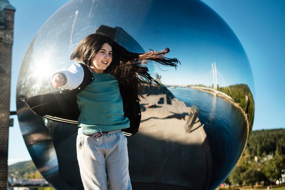 Eva-Marcela danser foran en stor statue av en speil-kule.