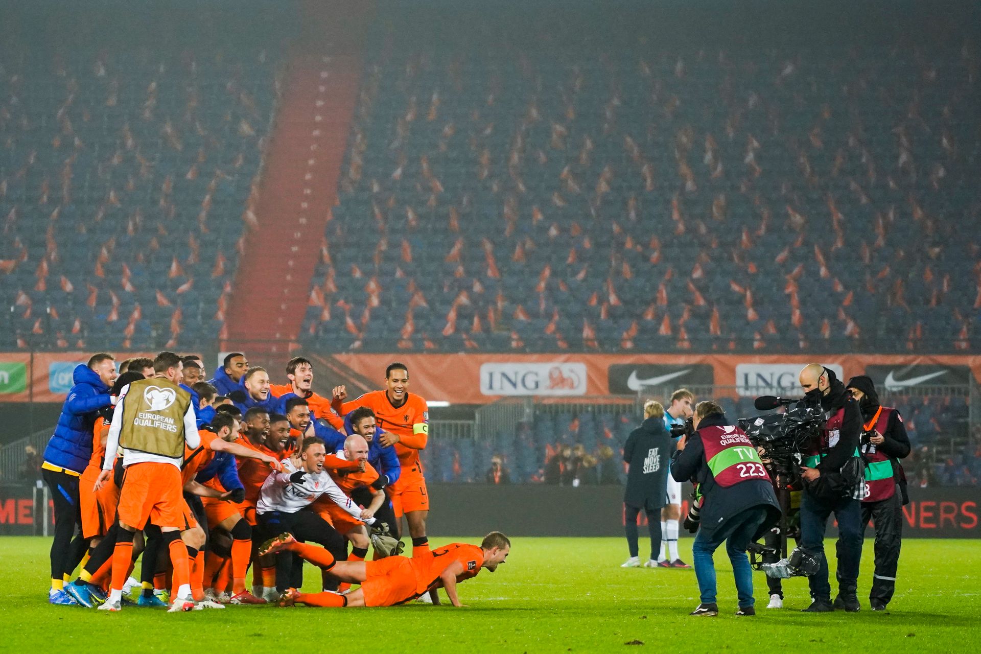 Jublende fotballspillere i oransje drakt tar et lagbilde