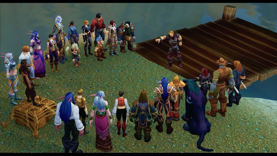 Bildet viser en scene fra spillet World of Warcraft der animerte karakterer står i en halvsirkel mens karakteren Ibelin, en høy og muskelløs mann med blondt hår, står i åpningen av halvsirkelen og peker på noen.