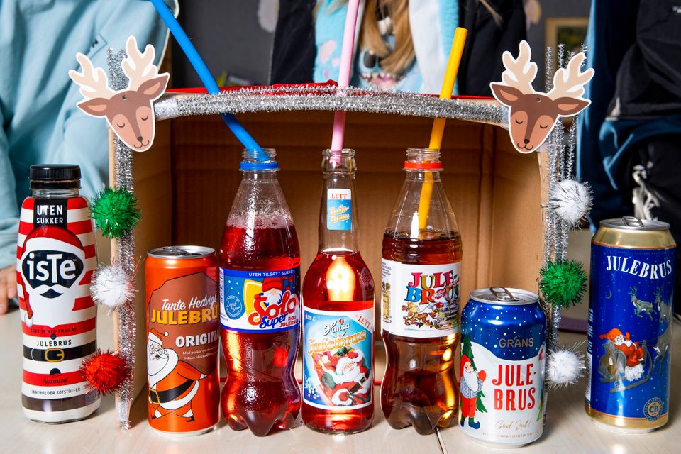 Syv forskjellige flasker med nisser og julemotiv på står oppstilt på rekke. 