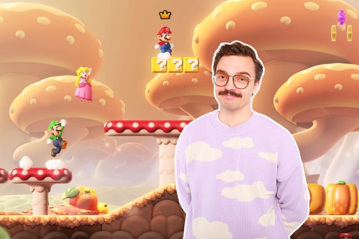 En mann med rosa genser og svart, kort hår og bart er klippet inn i et bilde fra et Super Mario-spill.