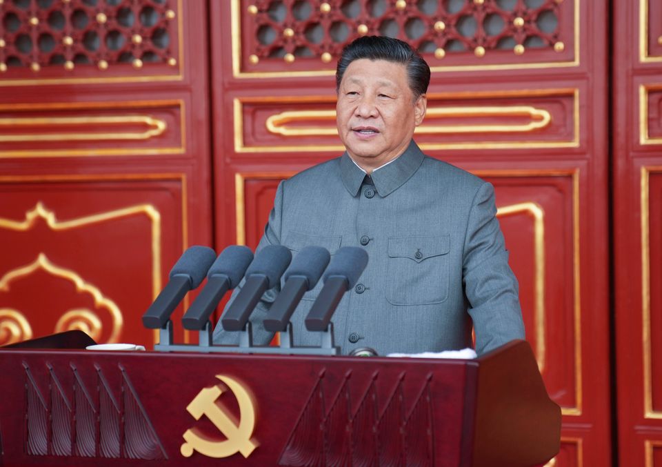 Xi Jinping, lederen i Kina, som står på en talerstol med flere mikrofoner. 