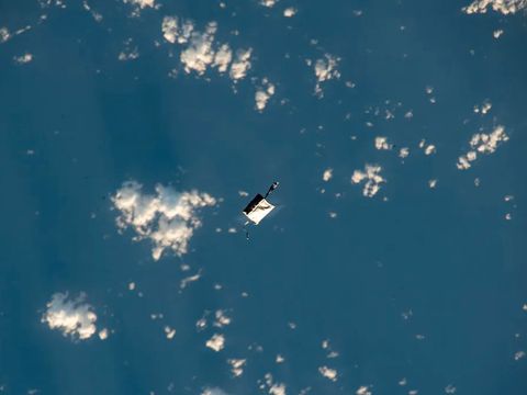 Et bilde tatt fra en romstasjon viser et rektangulært objekt som svever i atmosfæren over Jorden.