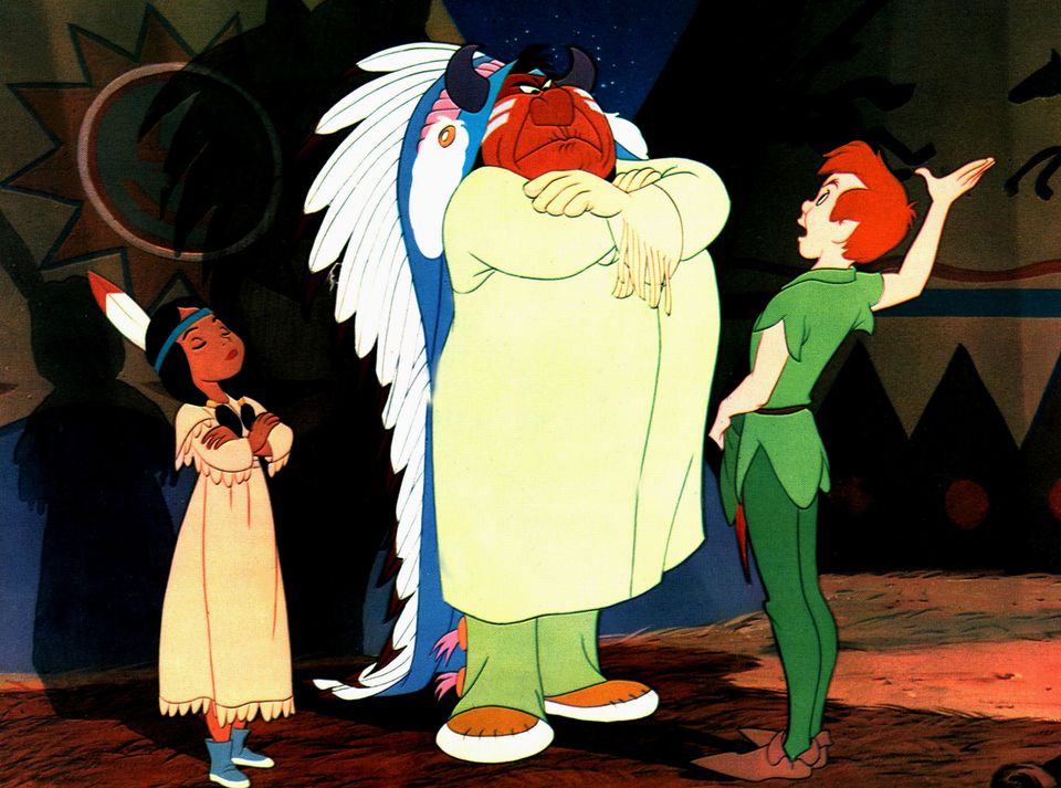 Et bilde fra tegnefilmen om Peter Pan, hvor Peter i grønne klær og rødt hår står foran en stor høvding som står med armene i kors og ser streng ut og en jente med en fjær i håret som også har armene i kors. 