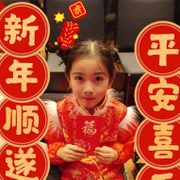 En ung jente med svart hår sitter og ved siden av seg er det flere runde sirkler med kinesiske tegn.