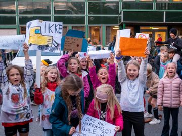 Flere barn holder oppe plakater i ulike farger hvor det står "ikke riv Harestad skole".