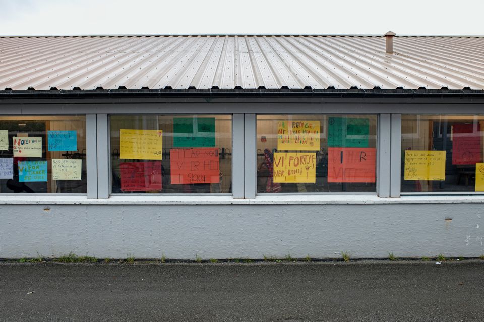 Mange plakater hvor det står "nå er det vår tur" og "vi vil ha ny skole" henger i vinduene på den grå skolen.