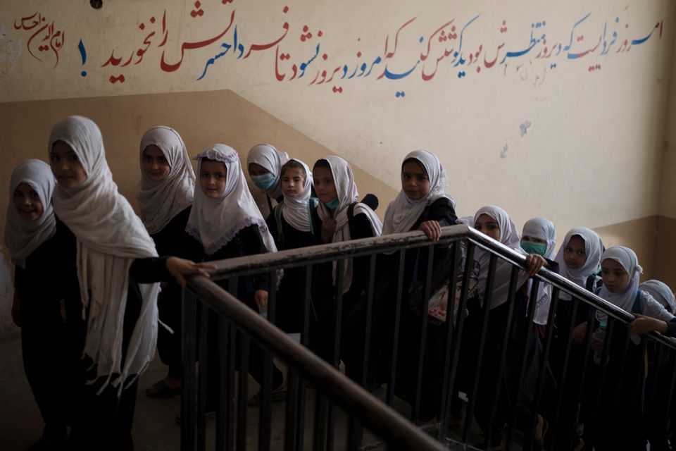 En gruppe jenter går opp en trapp i en skole.