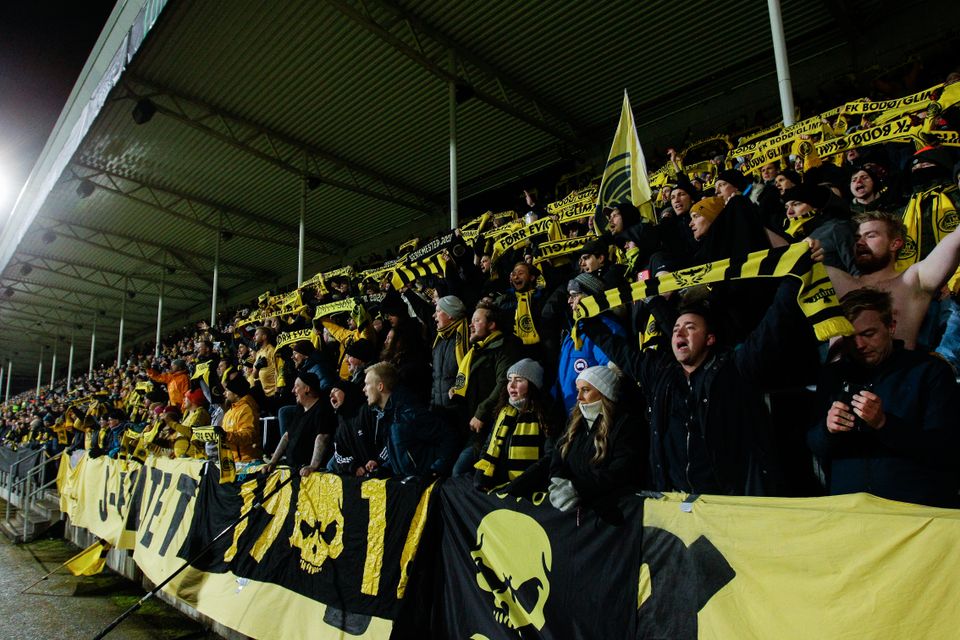 Mange supportere løfter Bodø/Glimt-skjeft opp i luften og synger.