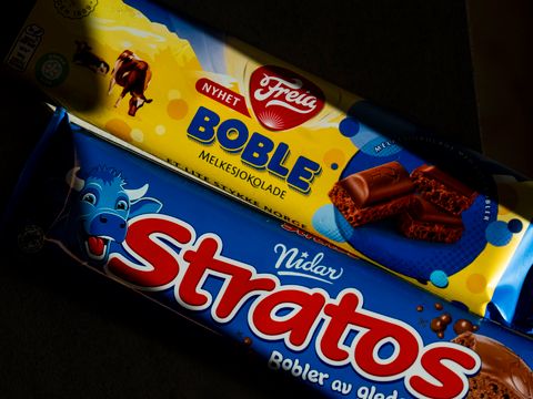 En blå plate med Nidar Stratos-sjokolade ligger ved siden av en gul og blå plate med Freia Boble-sjokolade.