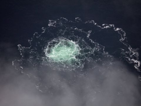 Et flyfoto viser et område med mørkeblått hav, og midt i bildet er det et turkis-hvitt felt med bobler som stiger til overflaten.