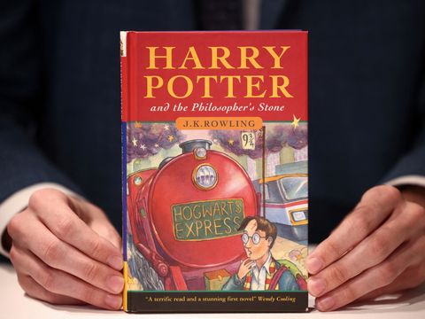 To hender som holder en førsteutgave av Harry Potter and the Philosophers Stone