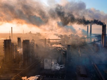 Oversiktsbilde som viser mange fabrikker som slipper ut røyk og gass.