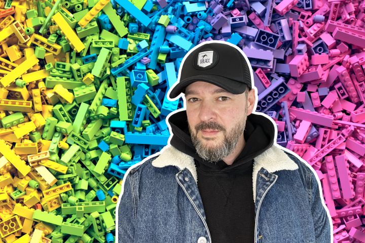 Bilde av en mann med caps og bakgrunnen er lego i forskjellige farger.