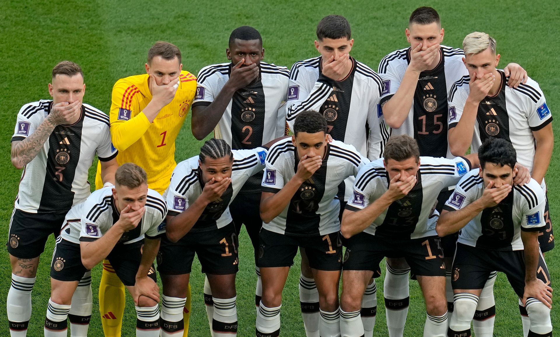 Et fotball-lag i svarte og hvite drakter står og holder seg for munnen.