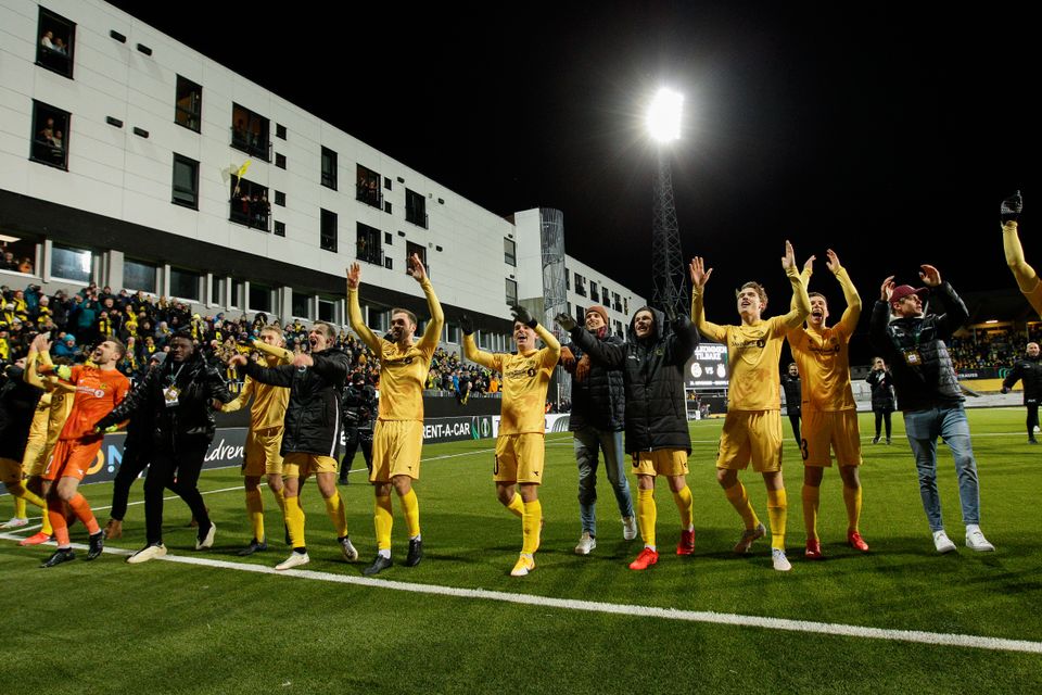 Bodø/Glimt-spillerne står på rekke og jubler foran sine egne supportere.