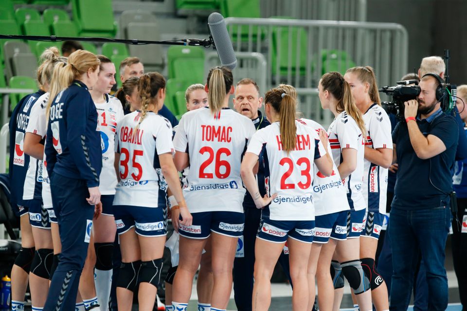 De norske håndballjentene står samlet rundt treneren for å få instrukser.