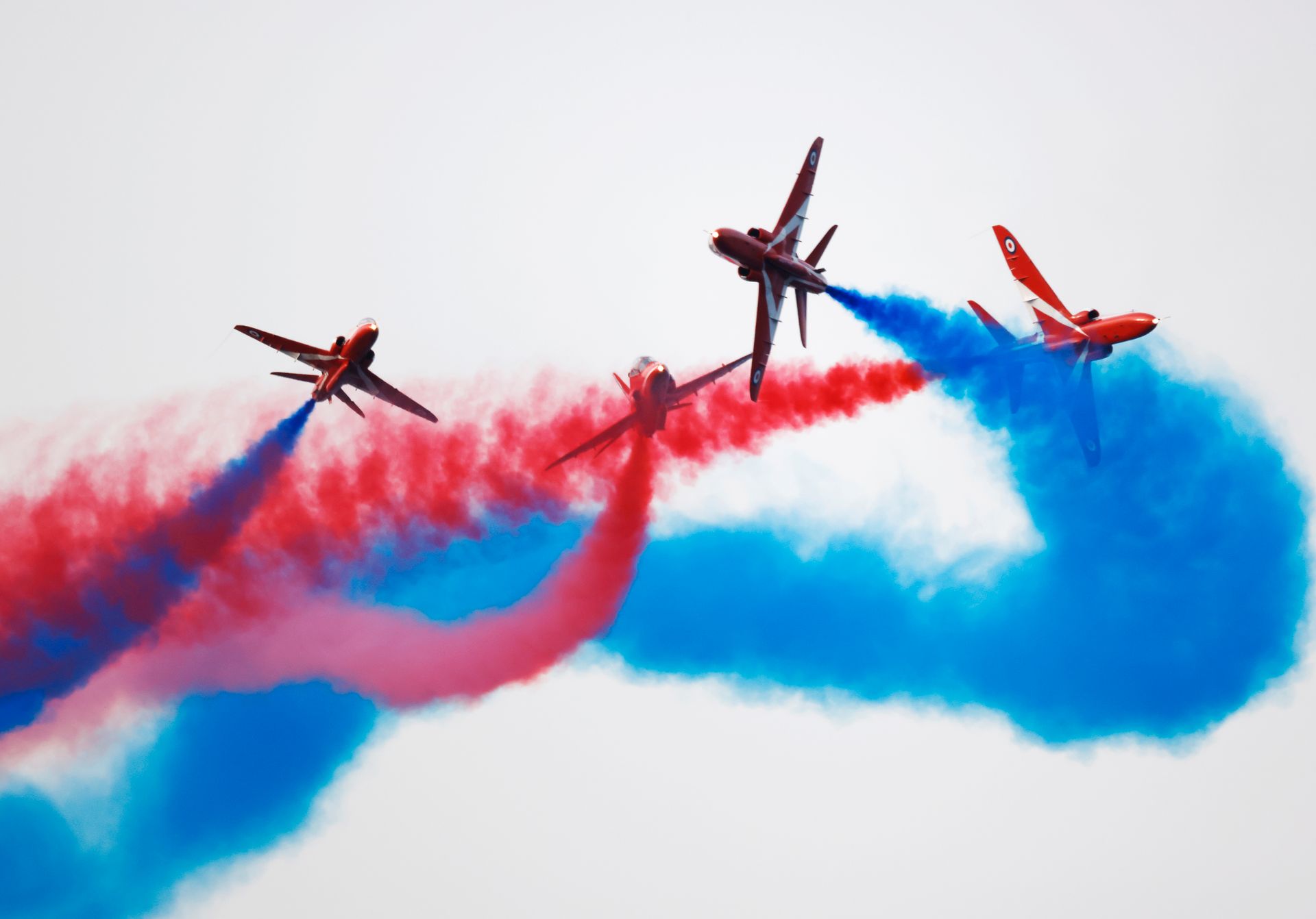 Fire fly gjør akrobatikk i luften, mens de slipper ut fargepulver som lager røde og blå striper bak flyene.