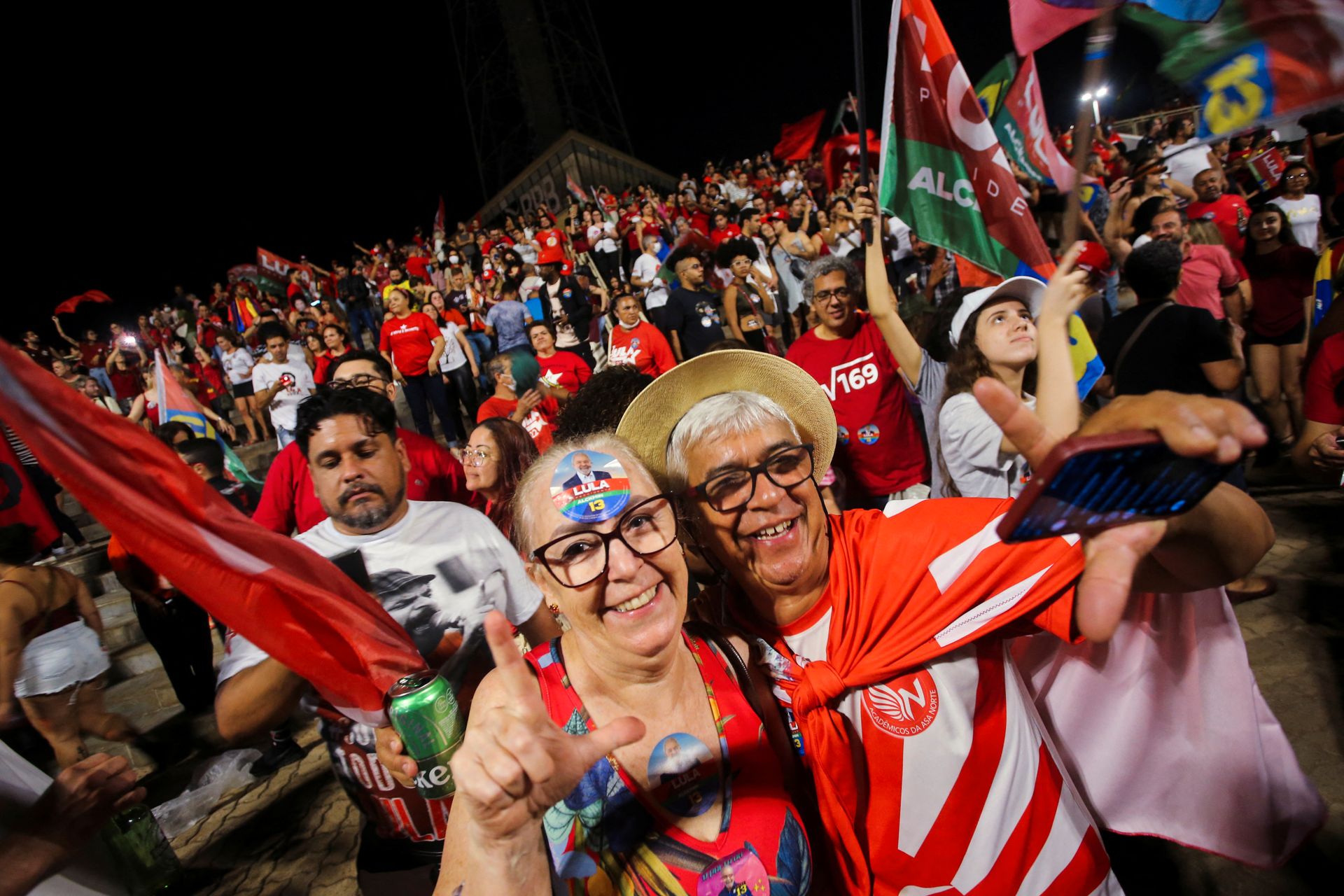 To kvinner smiler foran en mengde med Lula-tilhengere.