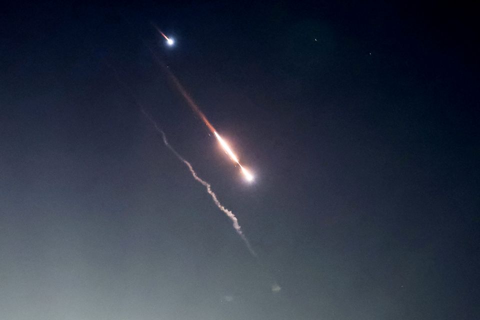 Flere raketter lyser opp en mørk himmel.